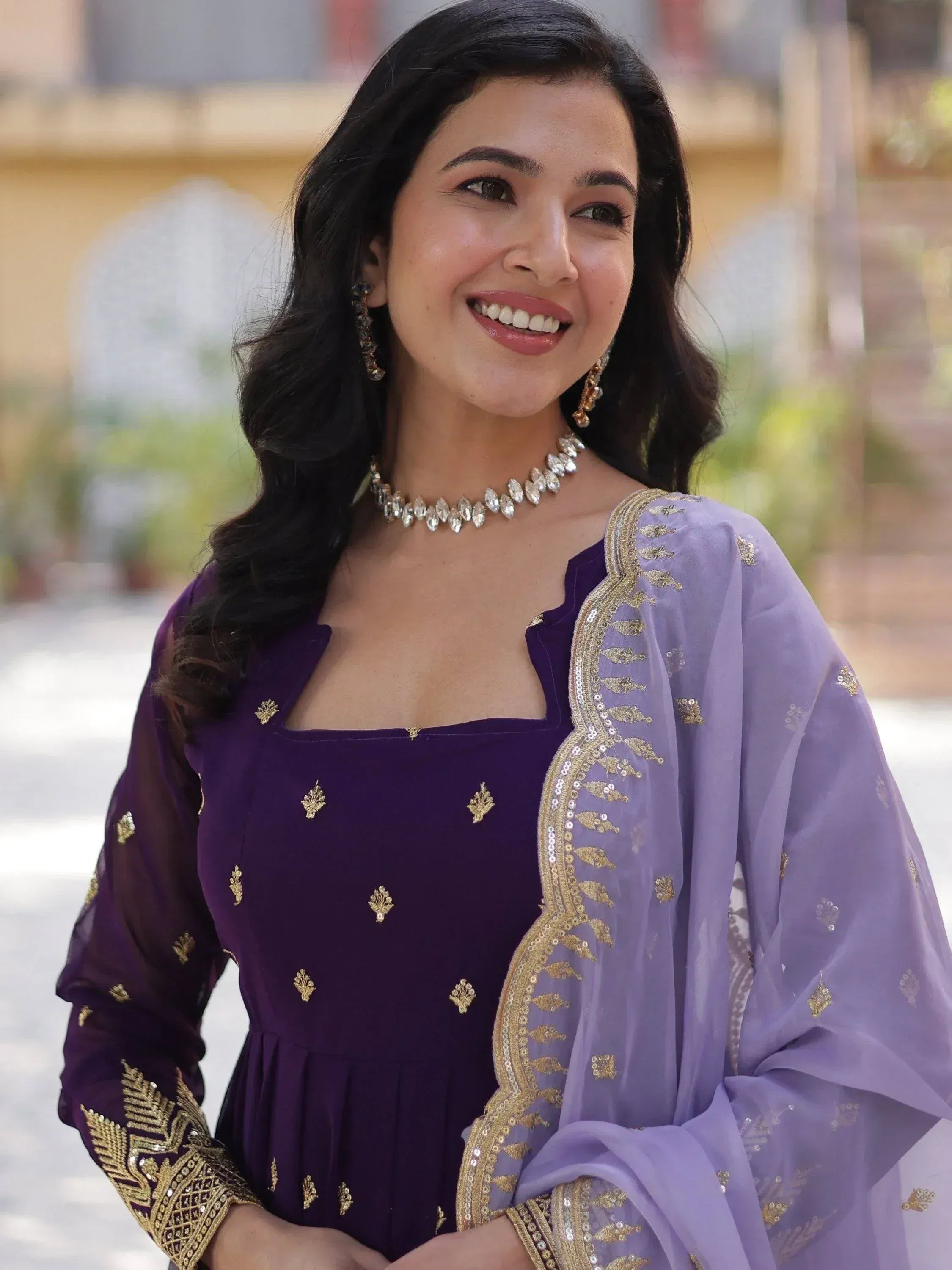 Purple embroidered ethnic gown with gold detailing and matching dupatta, perfect for Indian celebrations