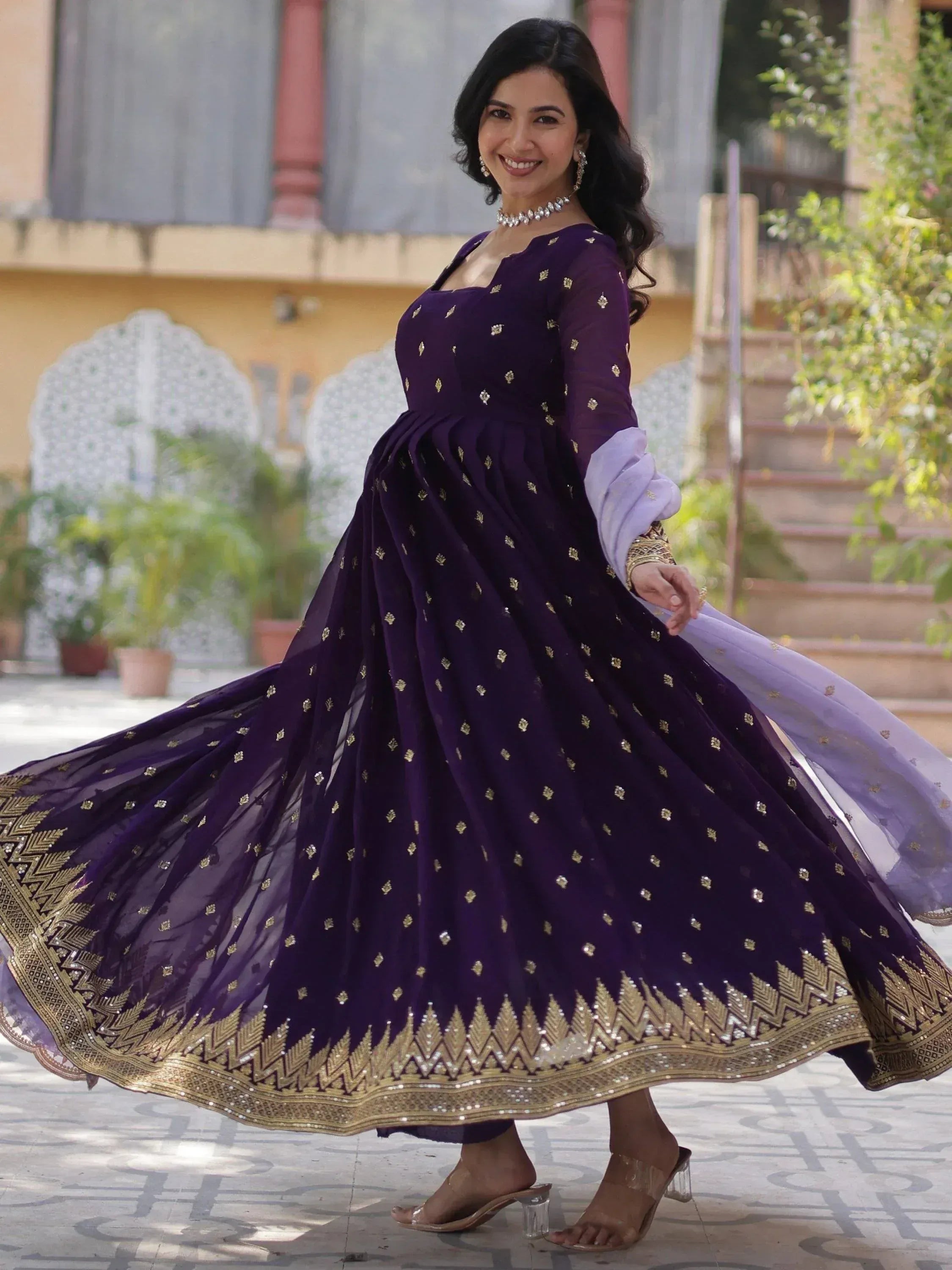 Elegant purple ethnic gown with gold embroidery, perfect for Indian celebrations and festive occasions.