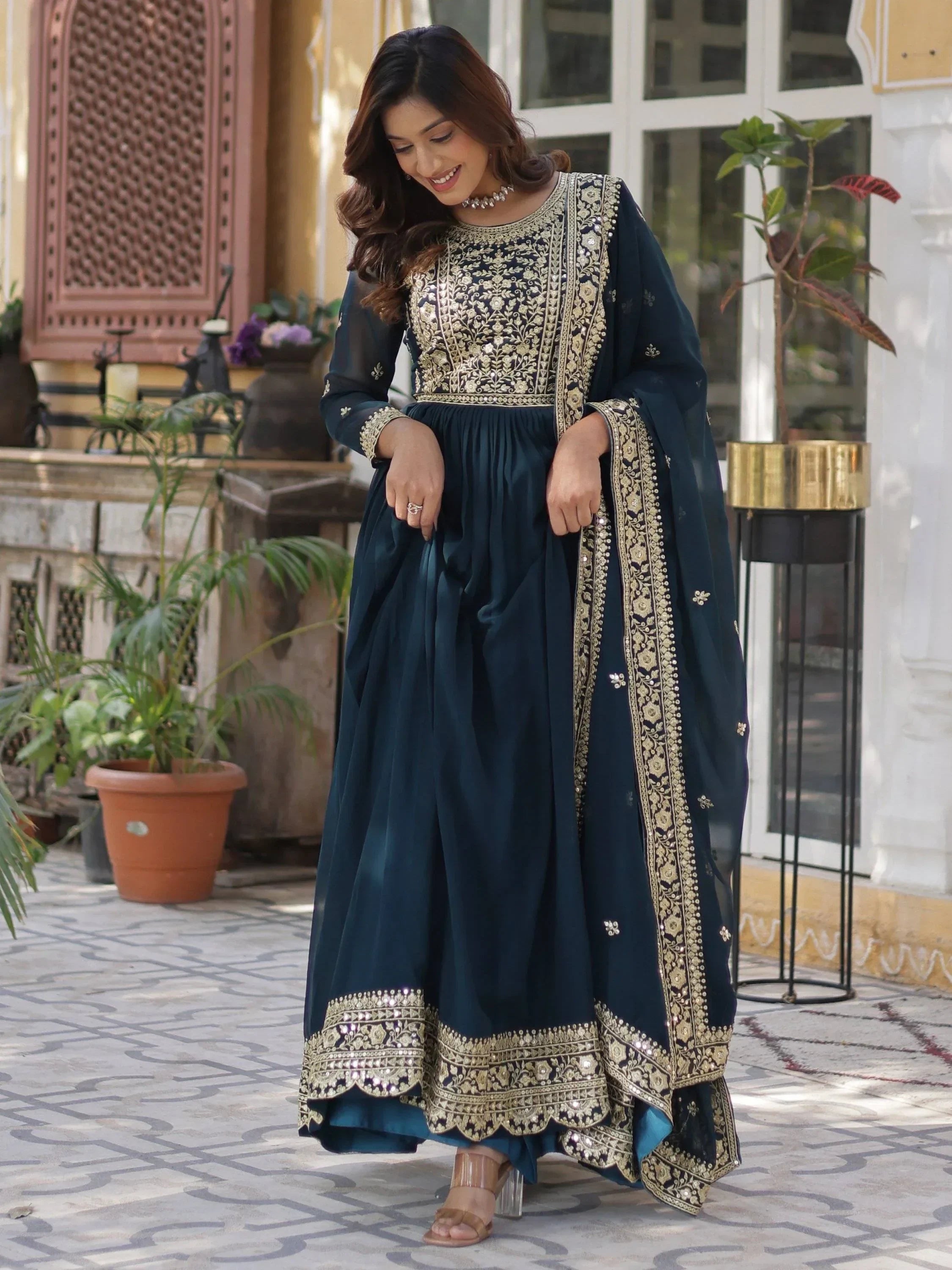 Woman in navy blue embroidered Indian ethnic gown with gold detailing and dupatta