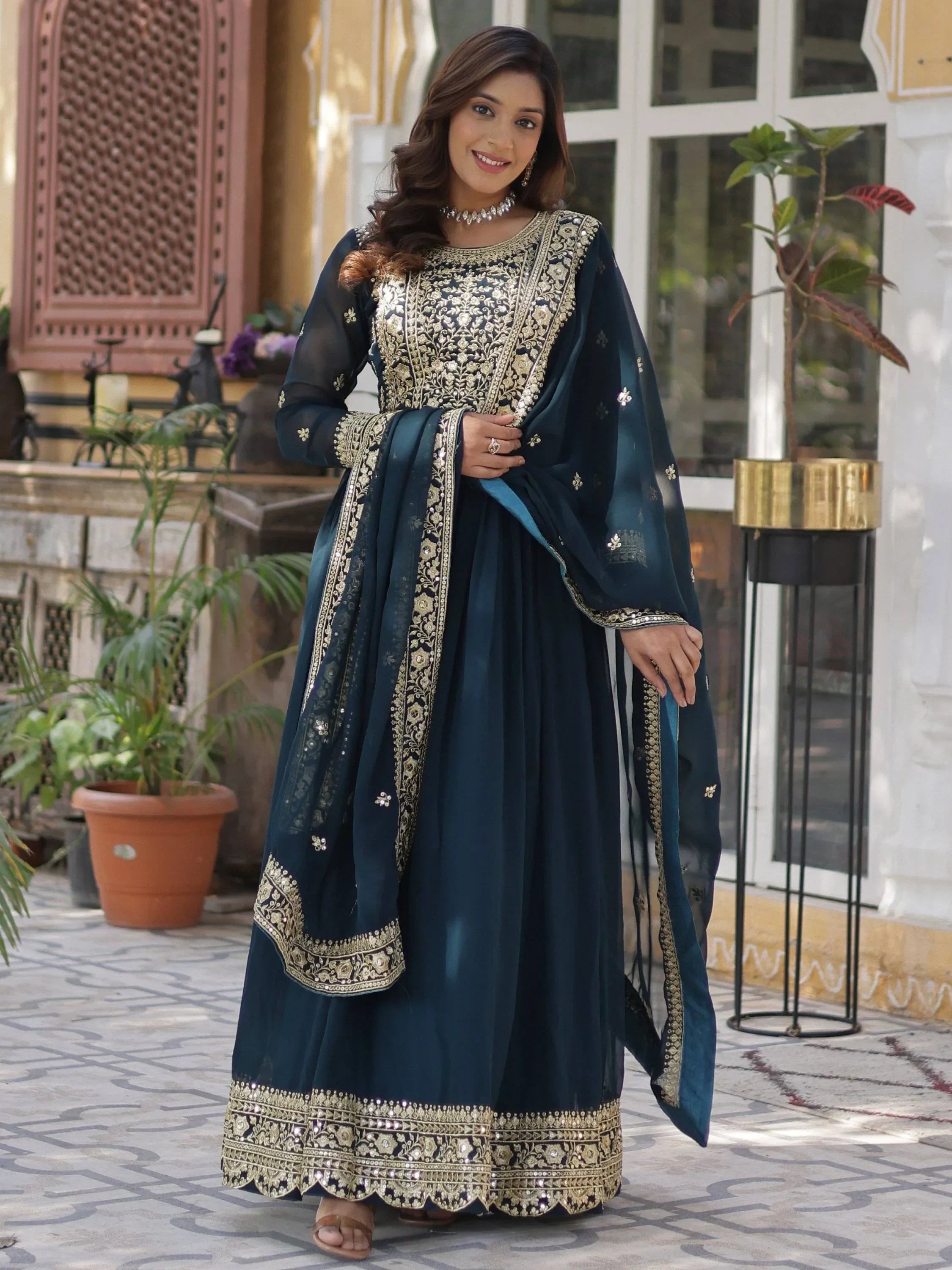 Woman in navy blue and gold embroidered anarkali gown, Indian ethnic wear, outdoor setting