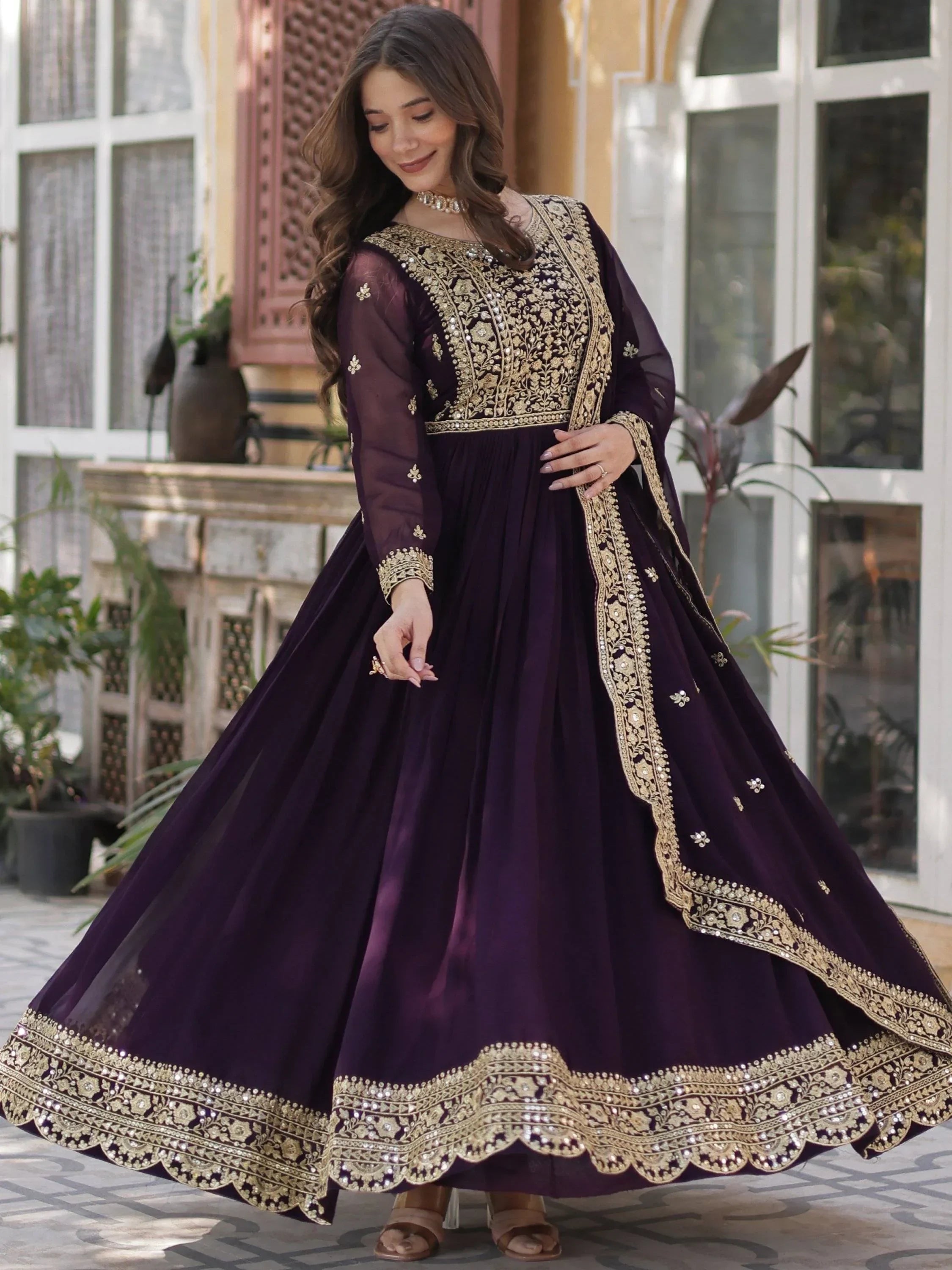 Woman in a wine purple embroidered Anarkali gown with gold detailing, traditional ethnic wear
