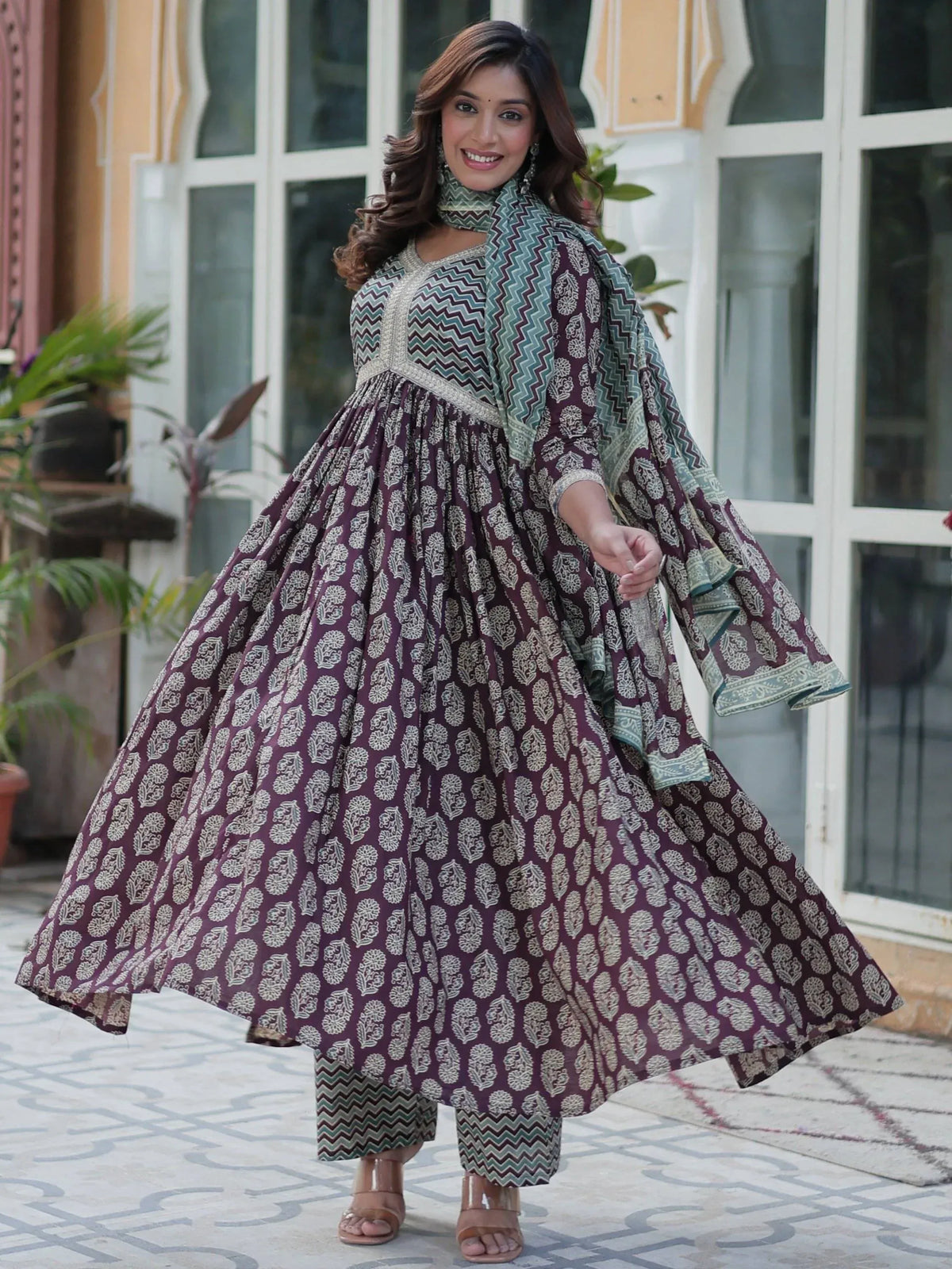 Woman in maroon printed Anarkali suit with green dupatta, ethnic Indian wear for festive occasions