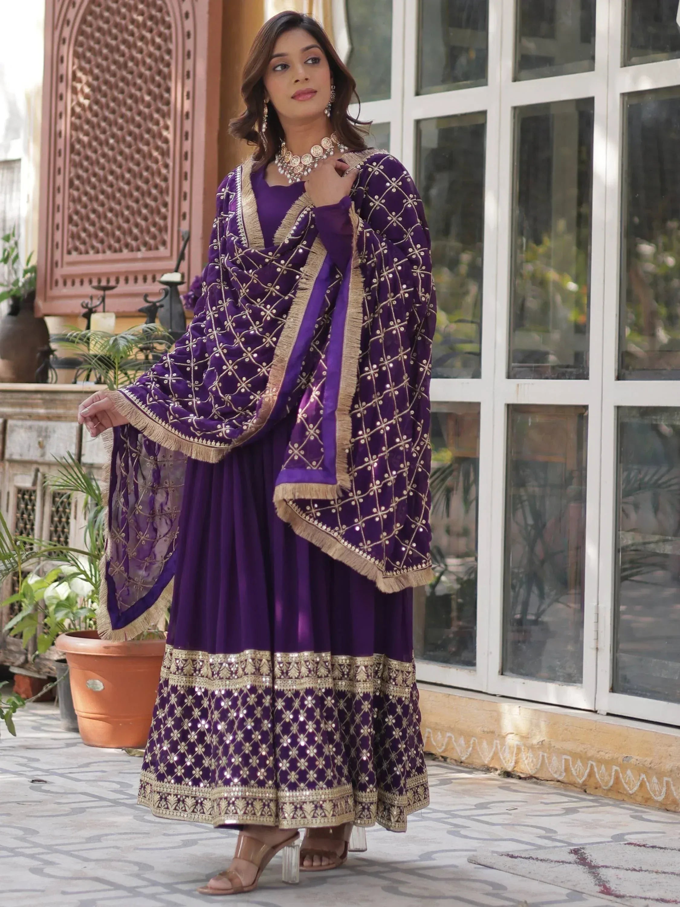 Purple ethnic gown with gold embroidery and fringe detailing, perfect for Indian celebrations.