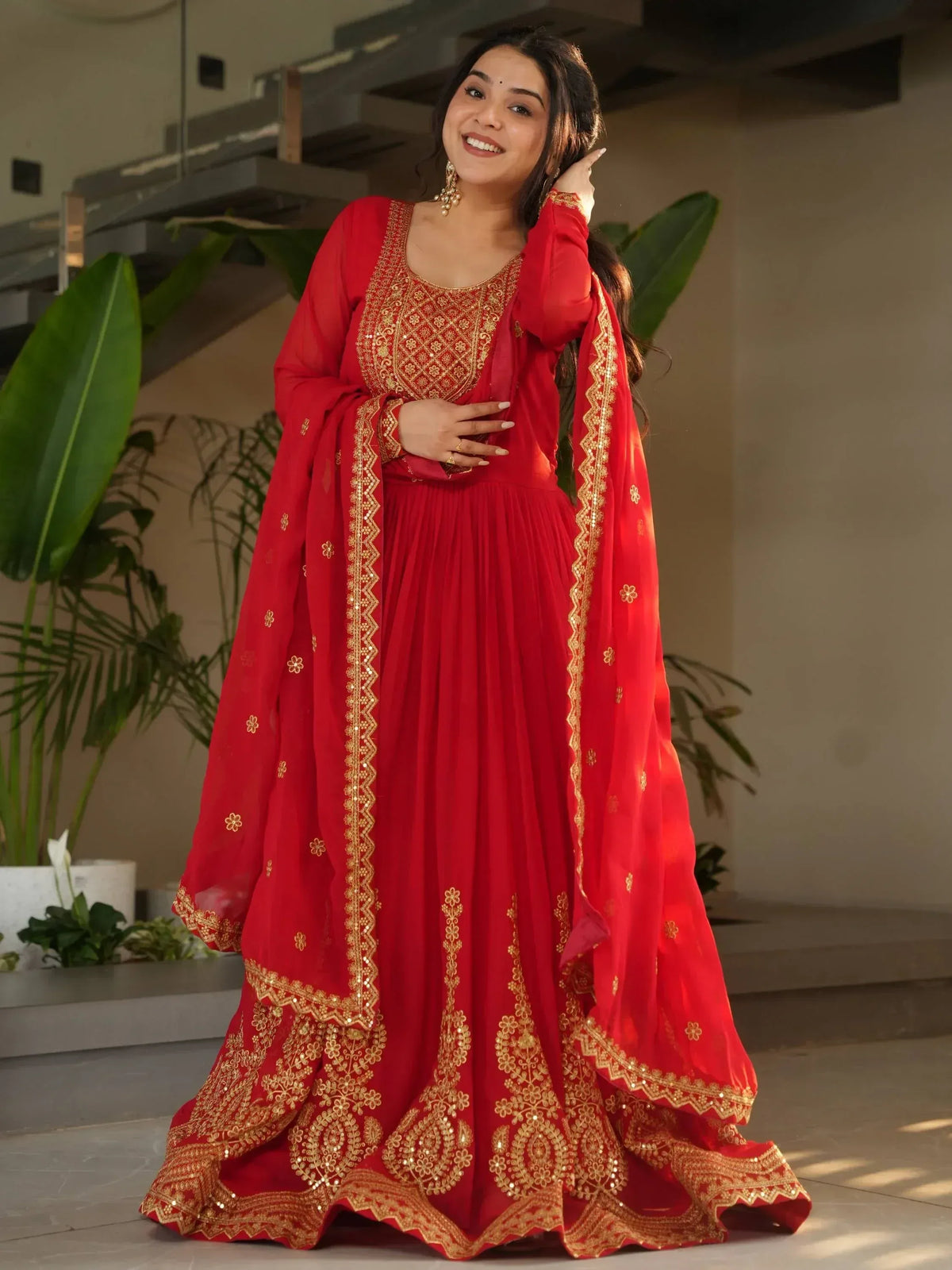 Red ethnic gown with gold embroidery, perfect for festive occasions and celebrations.