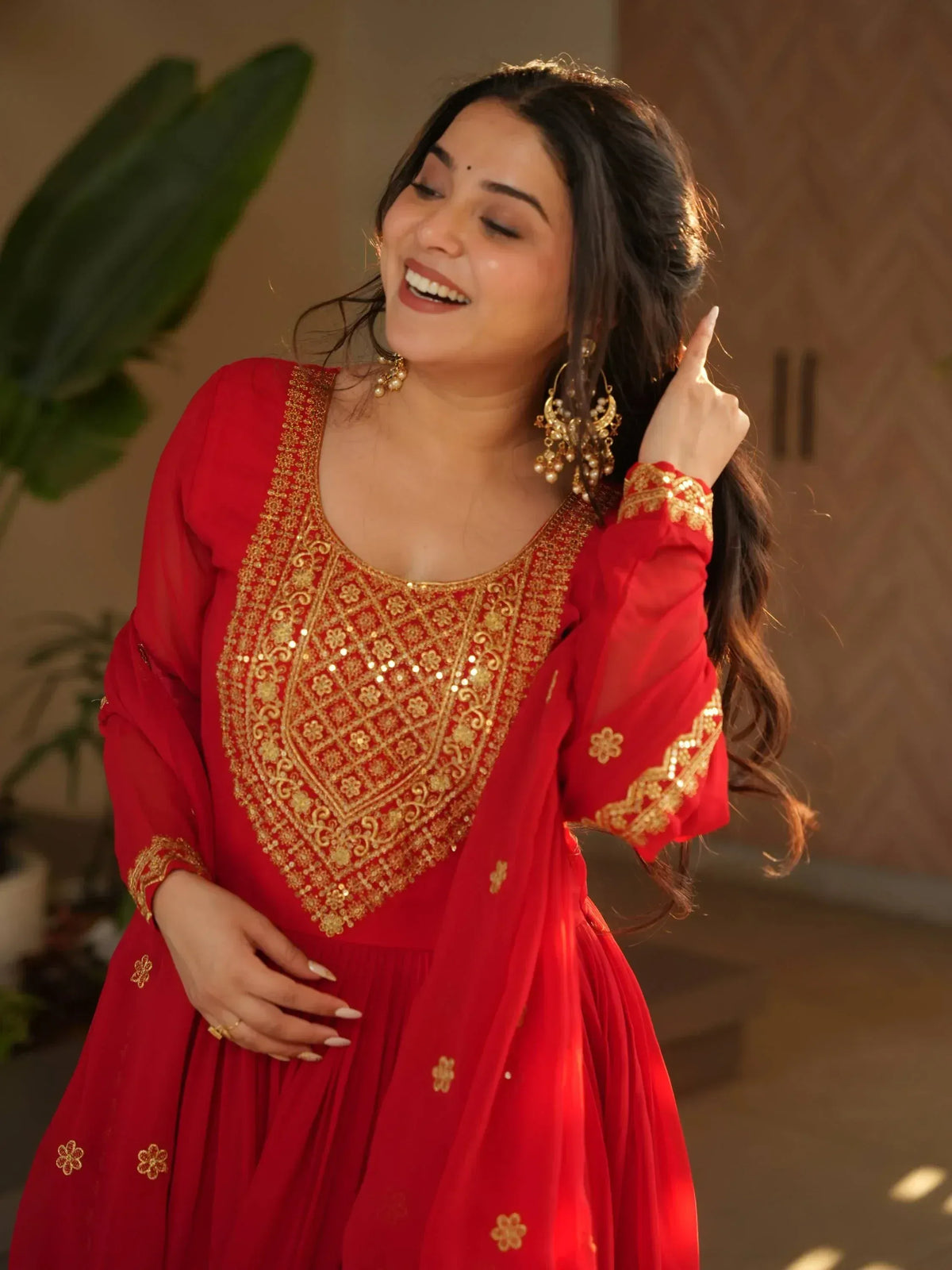 Red ethnic gown with gold embroidery, perfect for Indian festive wear and celebrations.