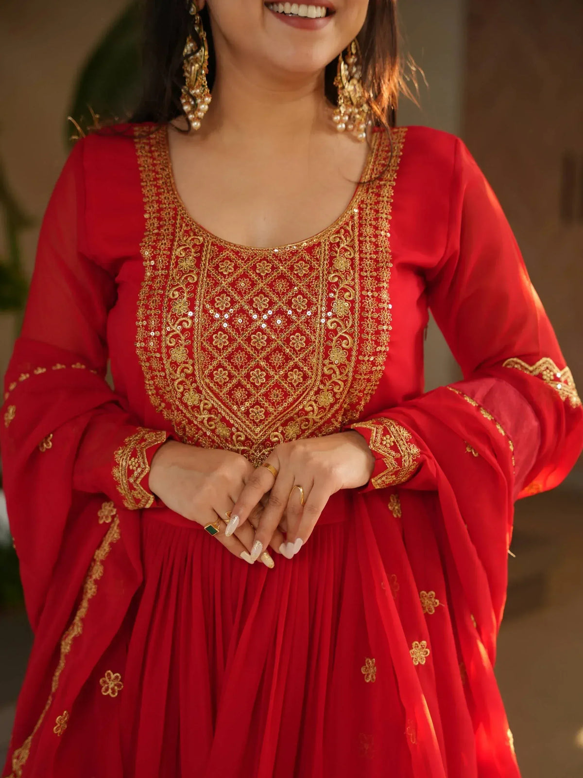 Red ethnic gown with gold embroidery and floral details, perfect for festive occasions.