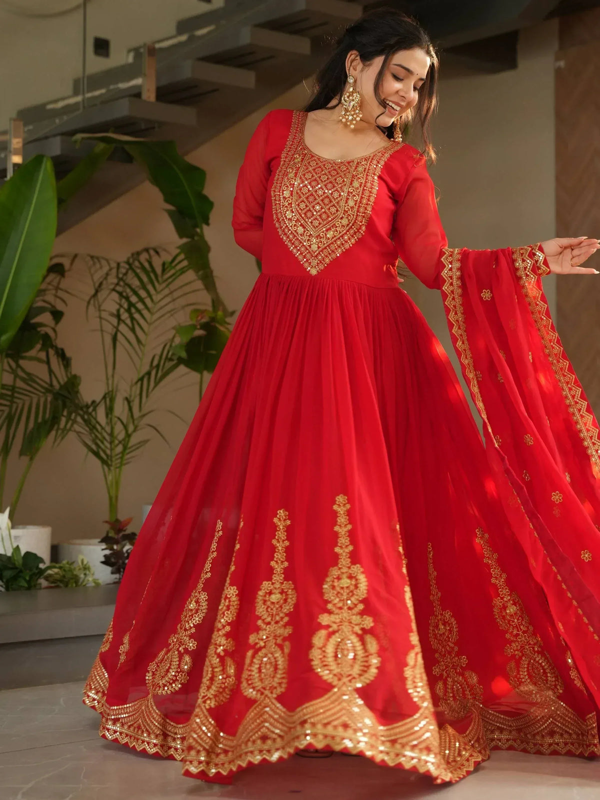 Red ethnic gown with gold embroidery, perfect for Indian weddings and festive occasions.