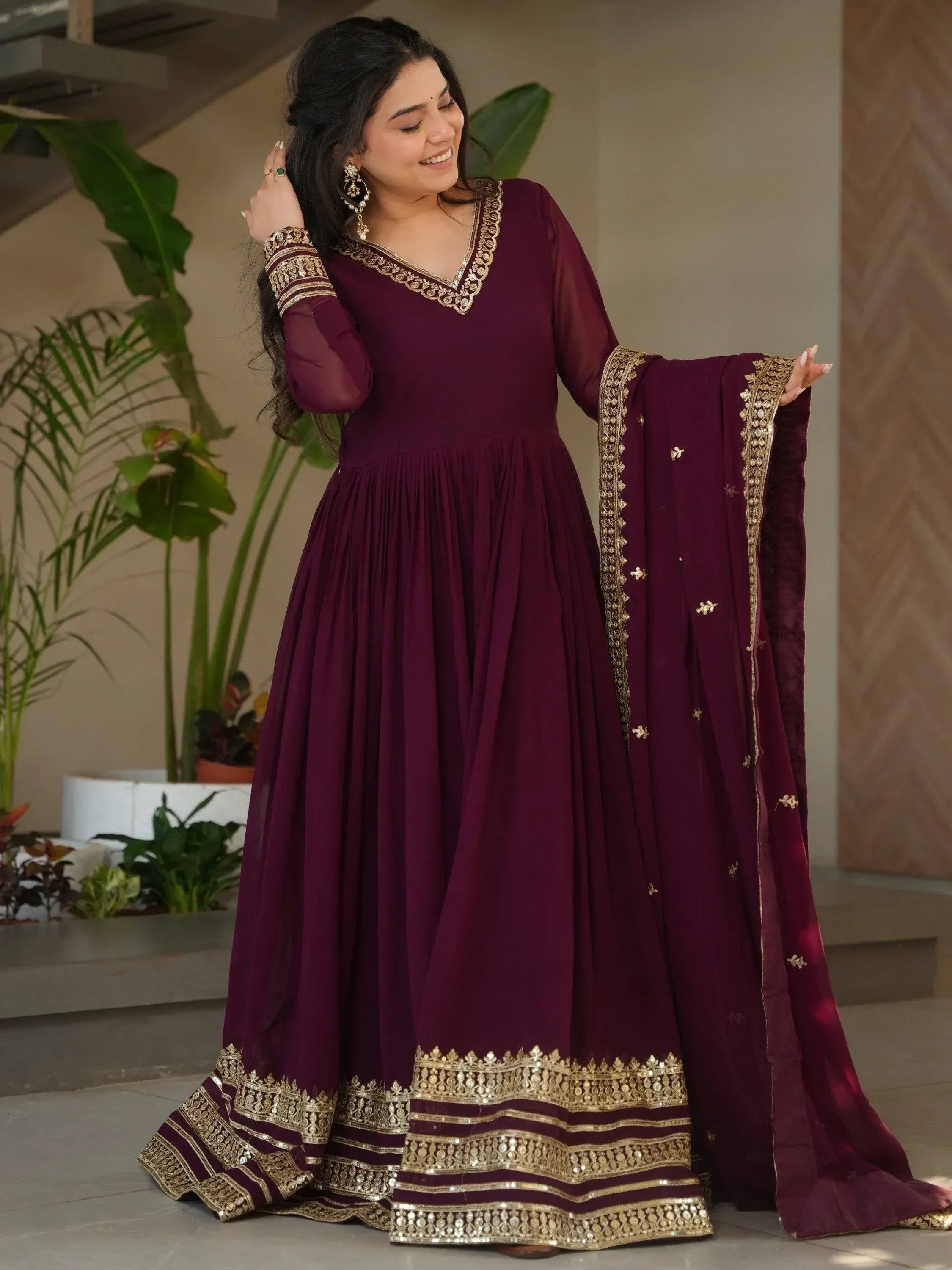 Elegant maroon ethnic gown with gold embroidery, perfect for Indian festive occasions and weddings.