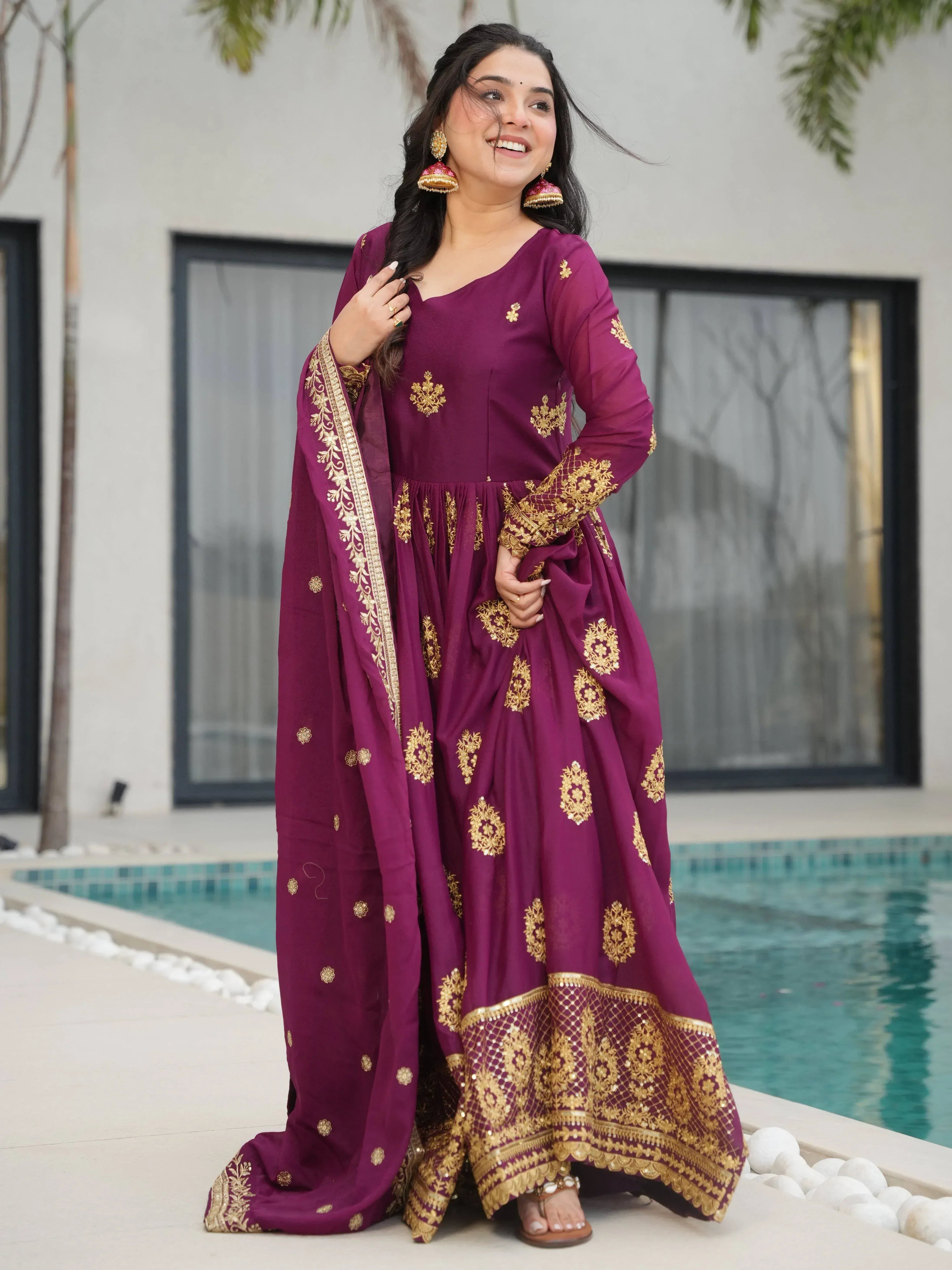 Woman in purple ethnic gown with gold embroidery, poolside, Indian designer wear