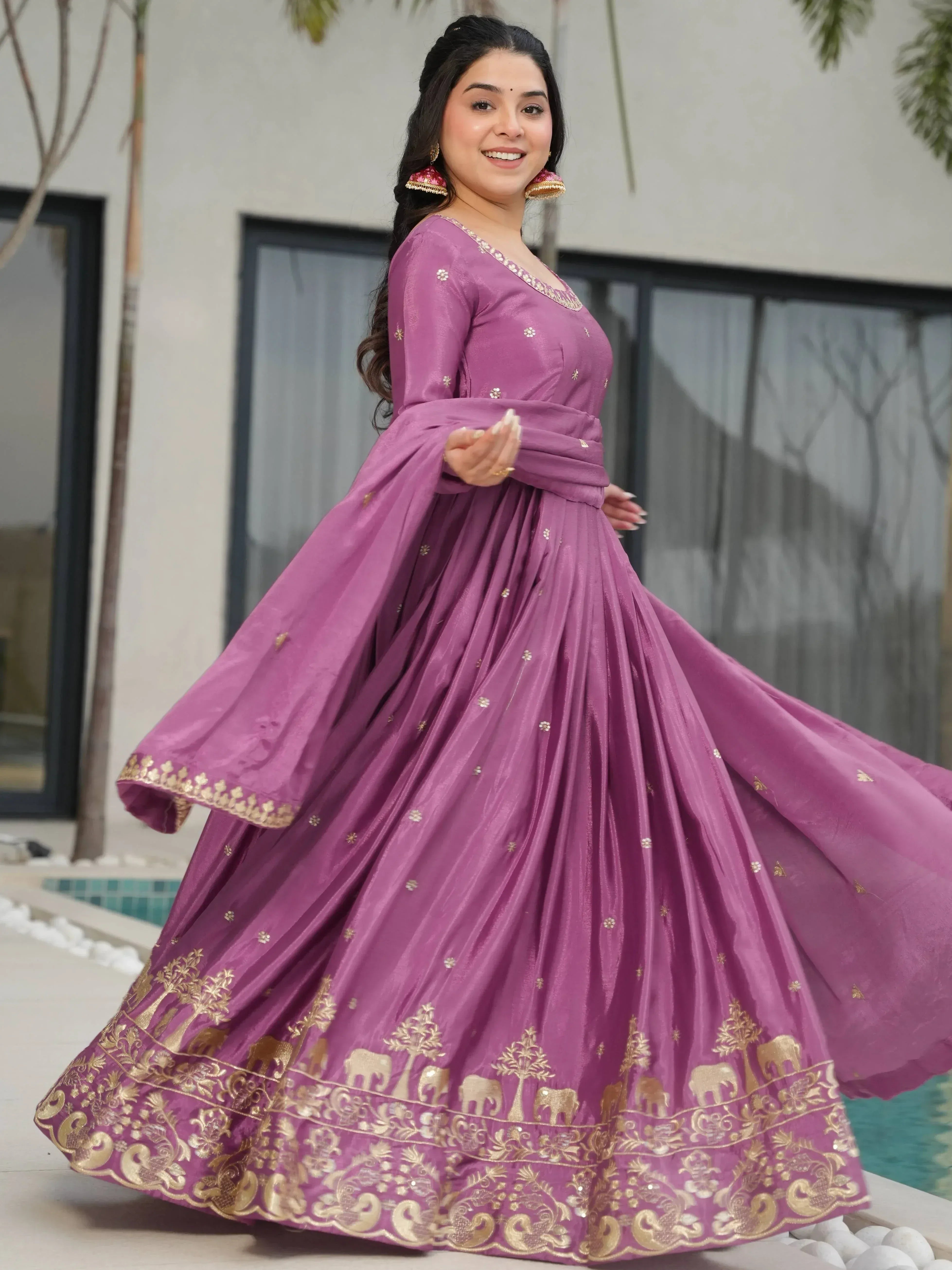Woman in purple Indian ethnic gown with gold elephant print, perfect for festive occasions and weddings.