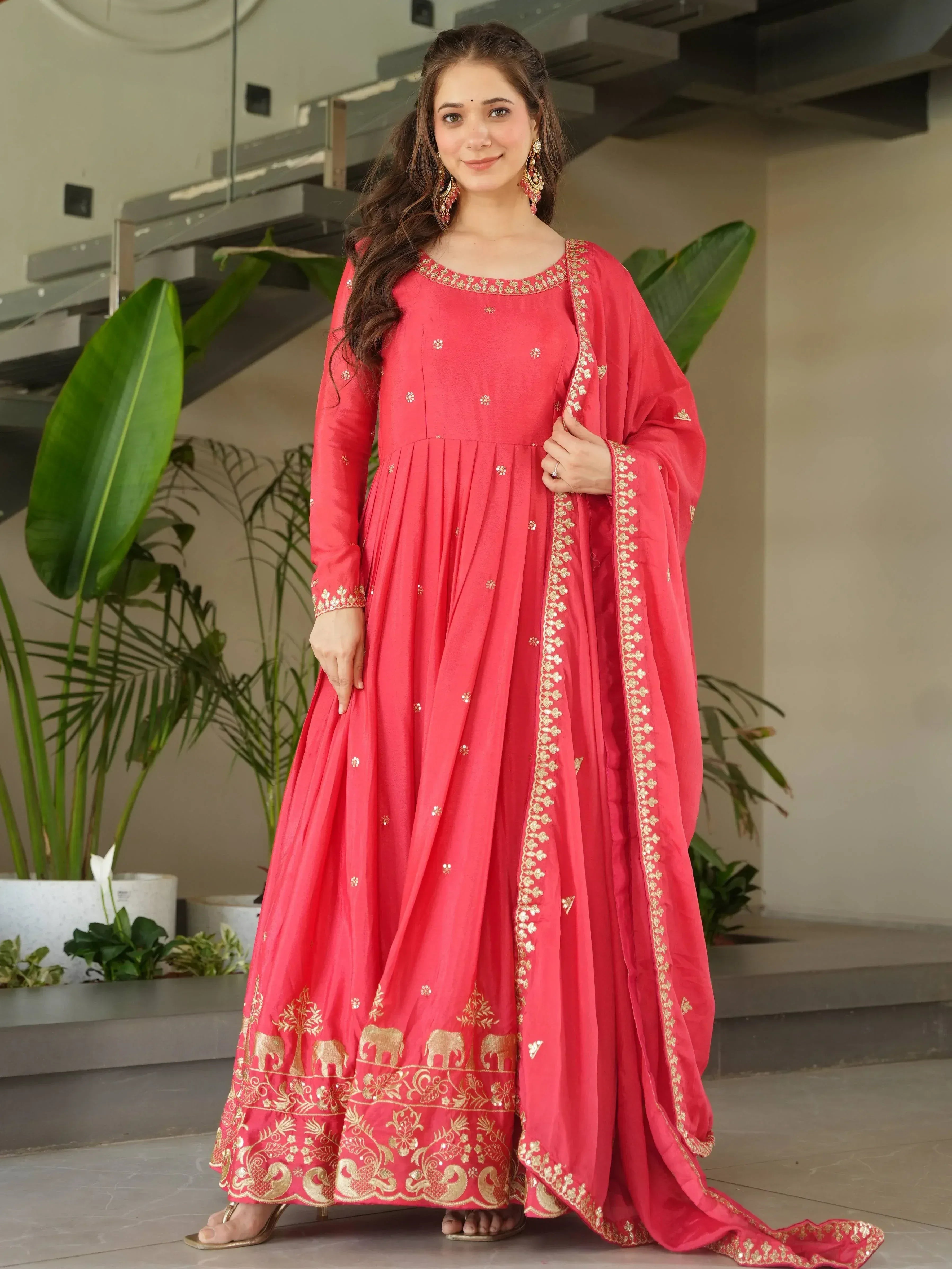 Red ethnic anarkali gown with gold embroidery and elephant motifs, perfect for Indian celebrations