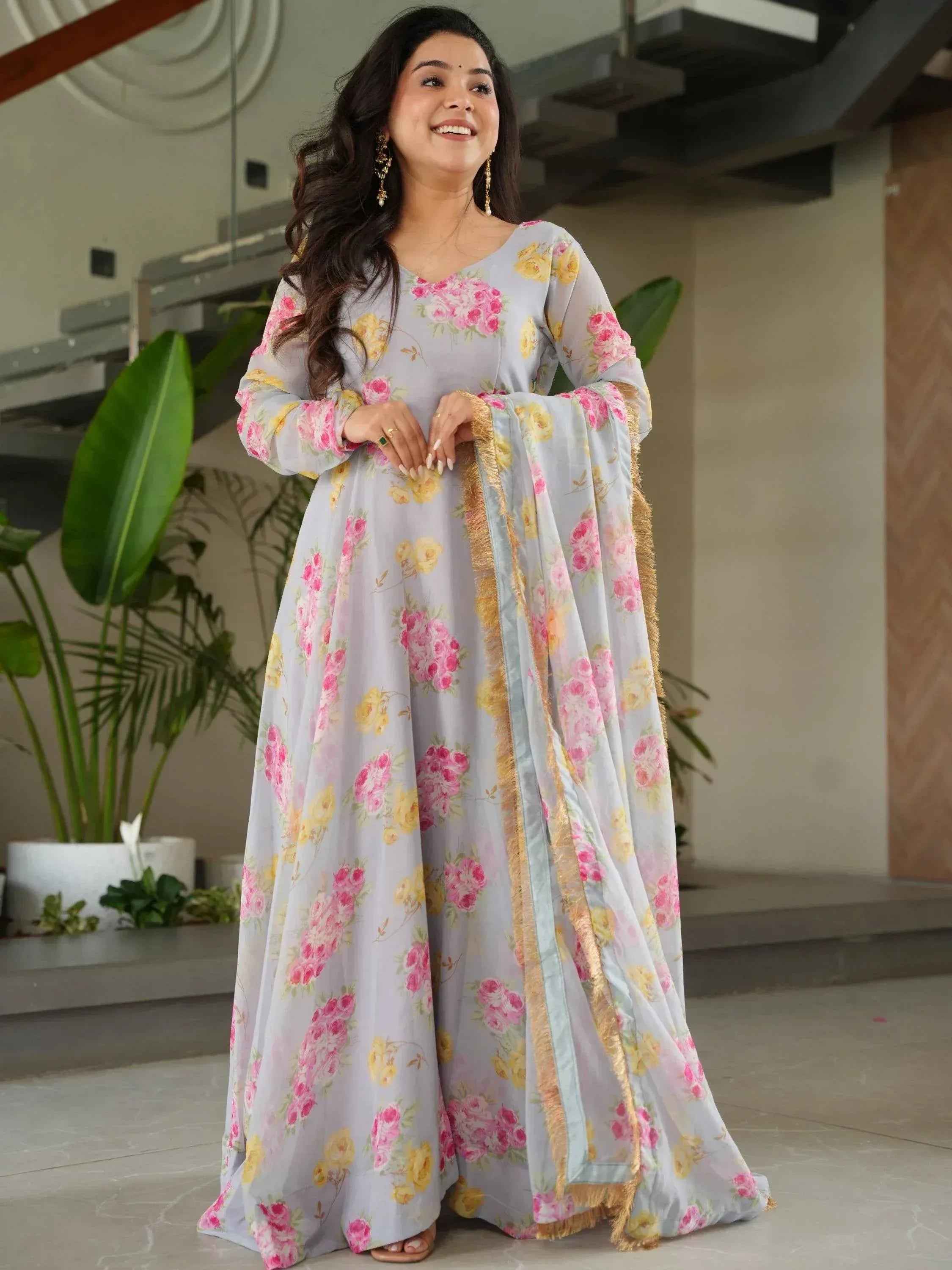 Woman in floral print Indian ethnic gown with gold trim, perfect for festive occasions