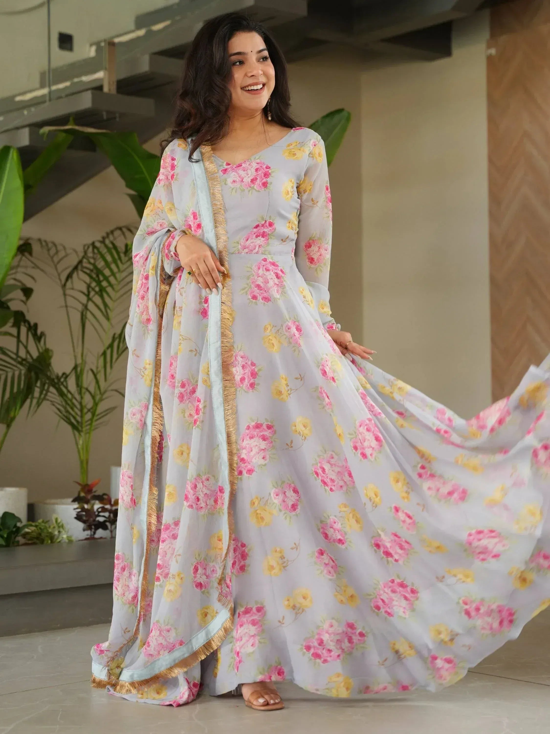 Woman in floral print ethnic gown with gold trim, perfect for Indian occasions