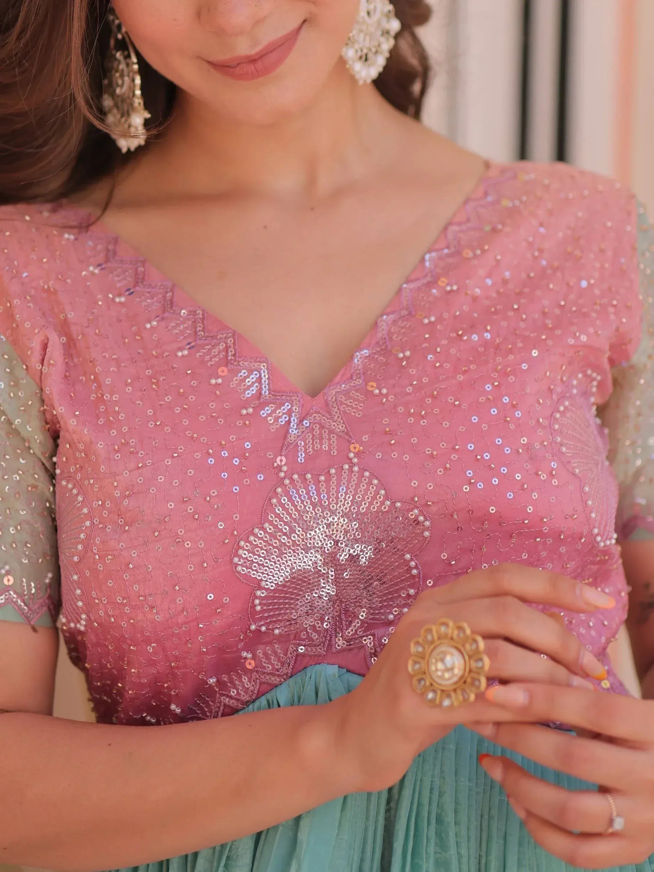 Pink sequin embroidered top with floral design, paired with mint pleated skirt, perfect for Indian ethnic wear occasions.