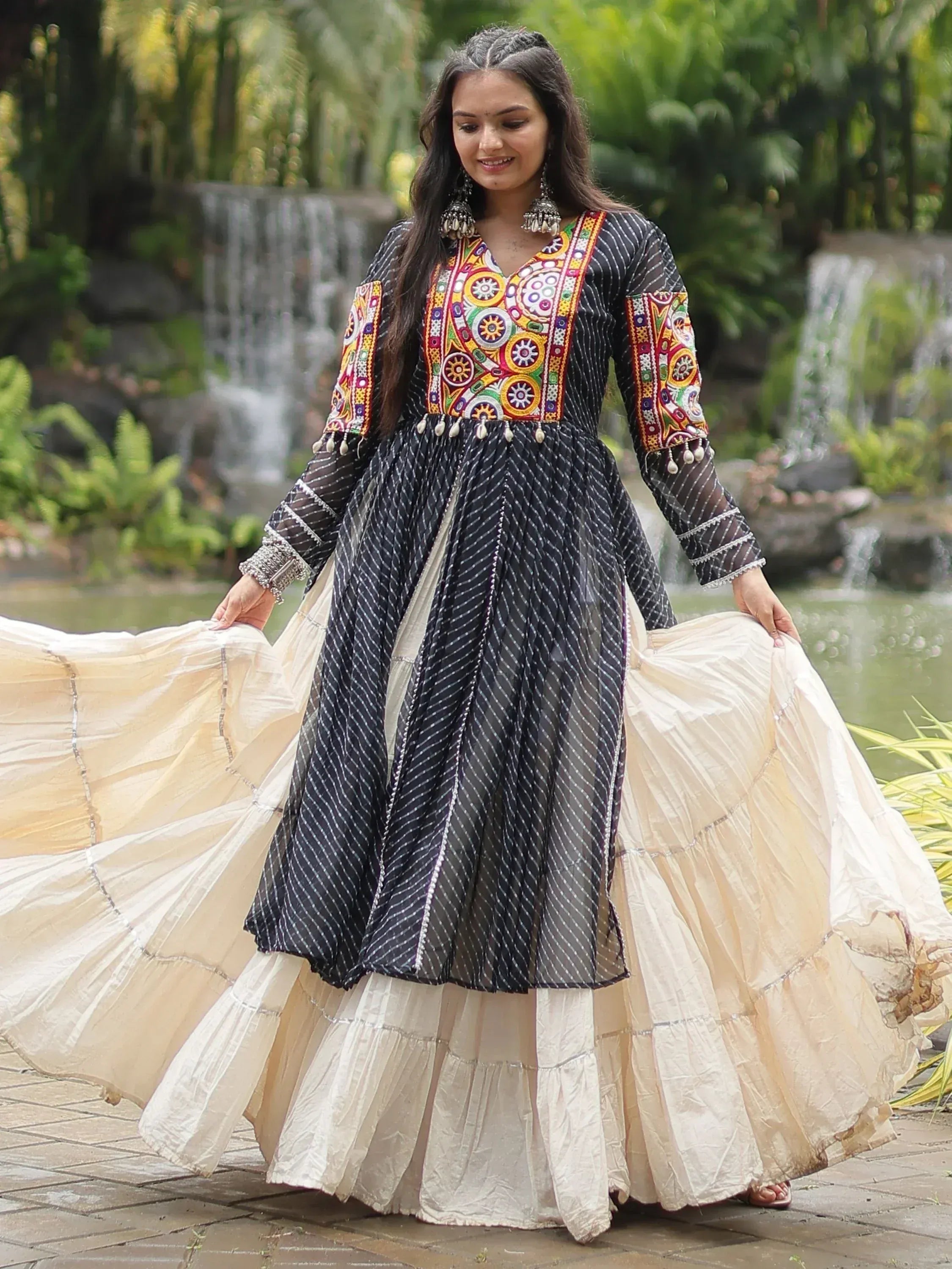 Woman in black and cream ethnic gown with colorful embroidery, perfect for Indian festive occasions.
