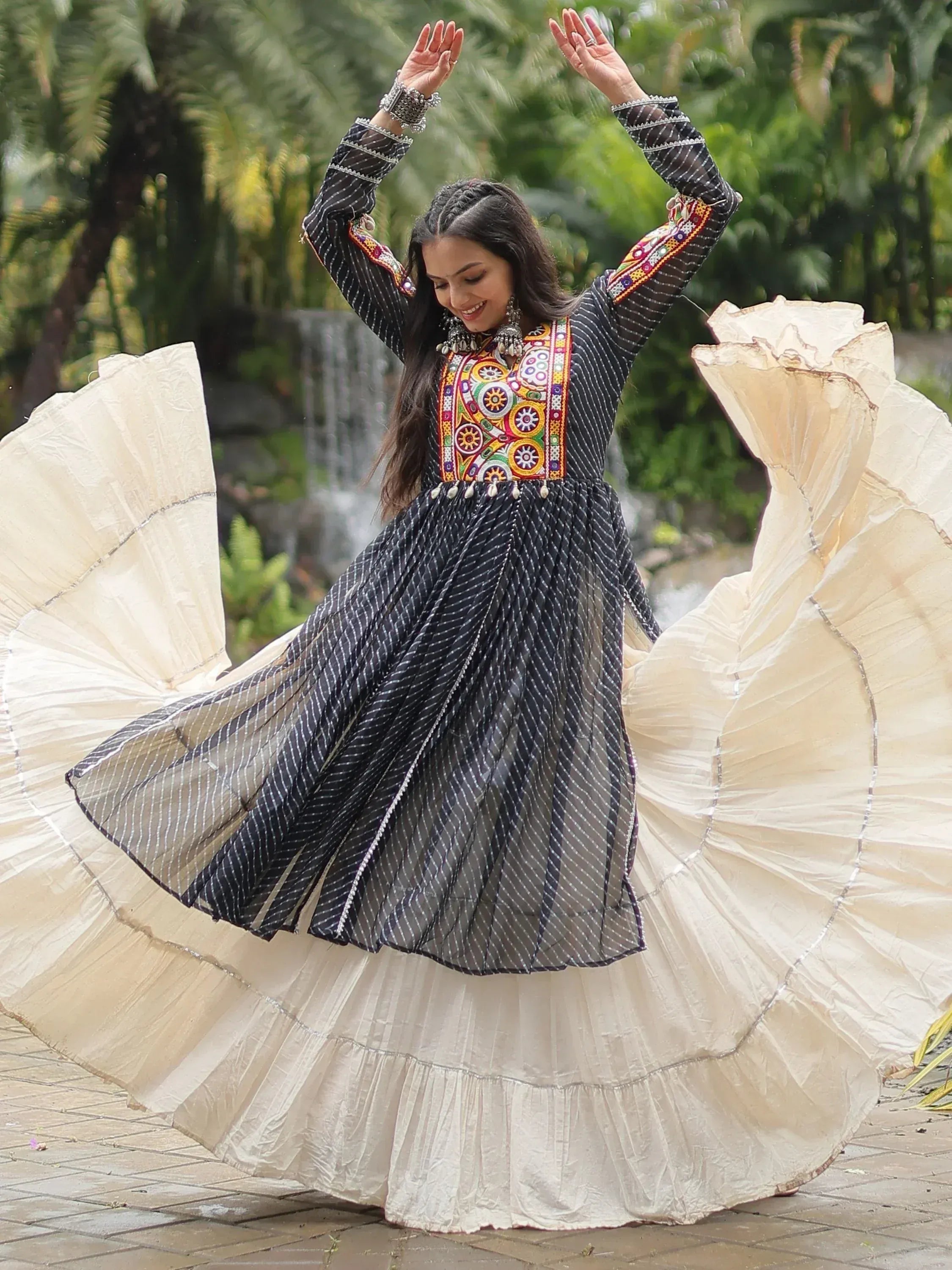 Woman twirling in black and cream ethnic gown with colorful embroidery, perfect for Indian festive occasions