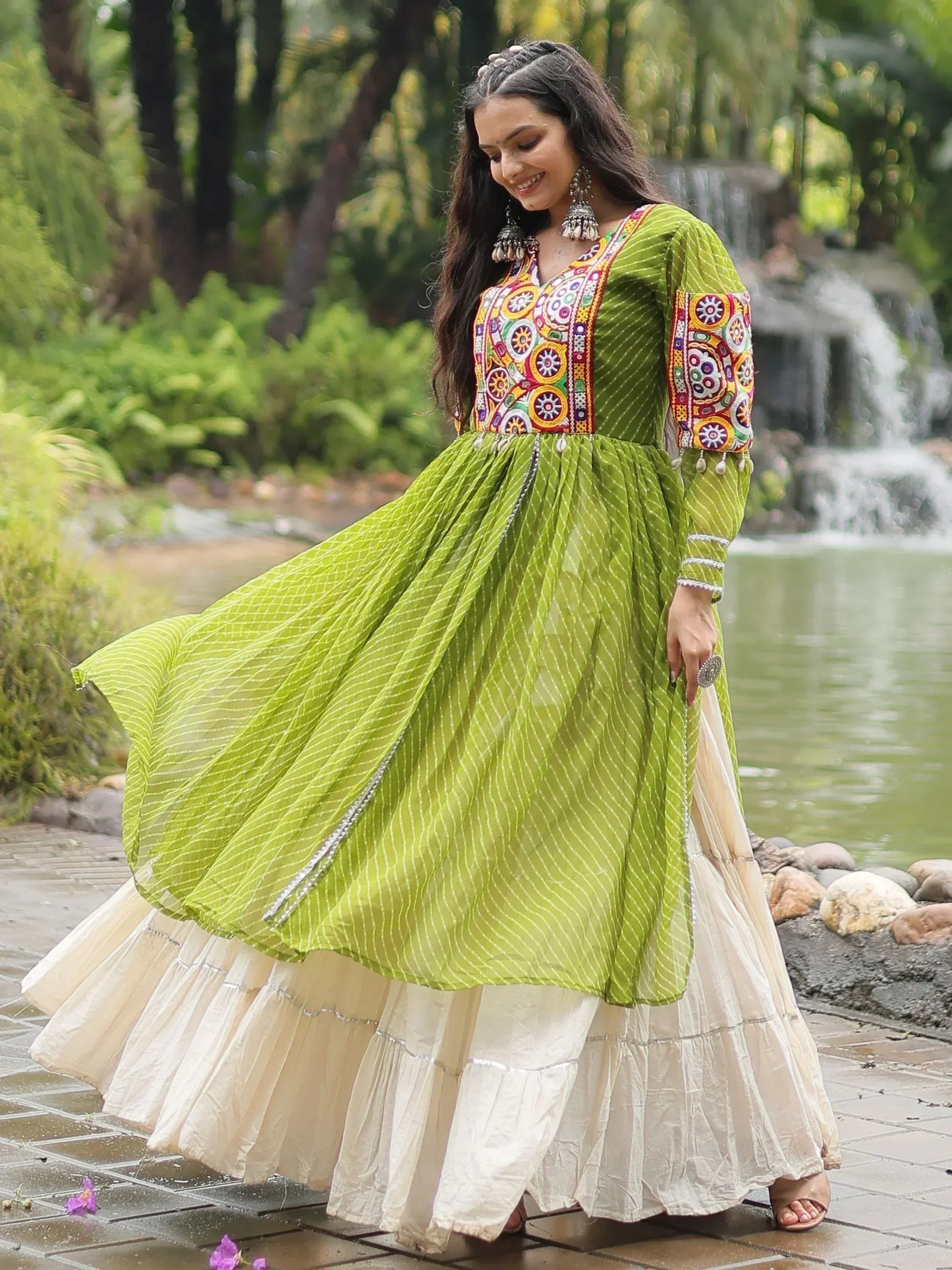 Woman in vibrant green embroidered ethnic gown with white tiered skirt, perfect for festive occasions