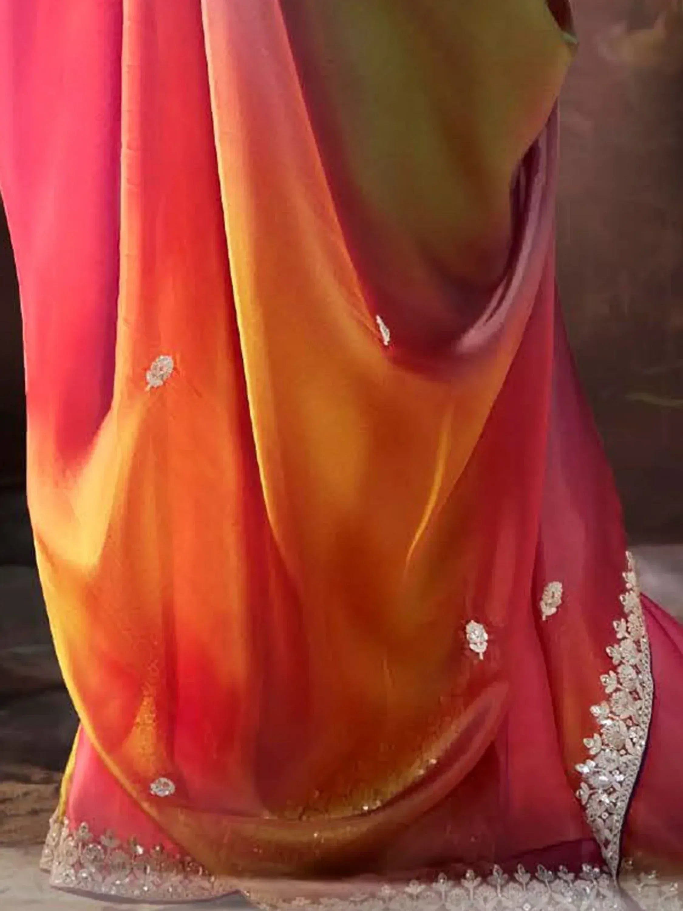 Vibrant ombre saree with red to yellow gradient, embellished border, and floral sequin details