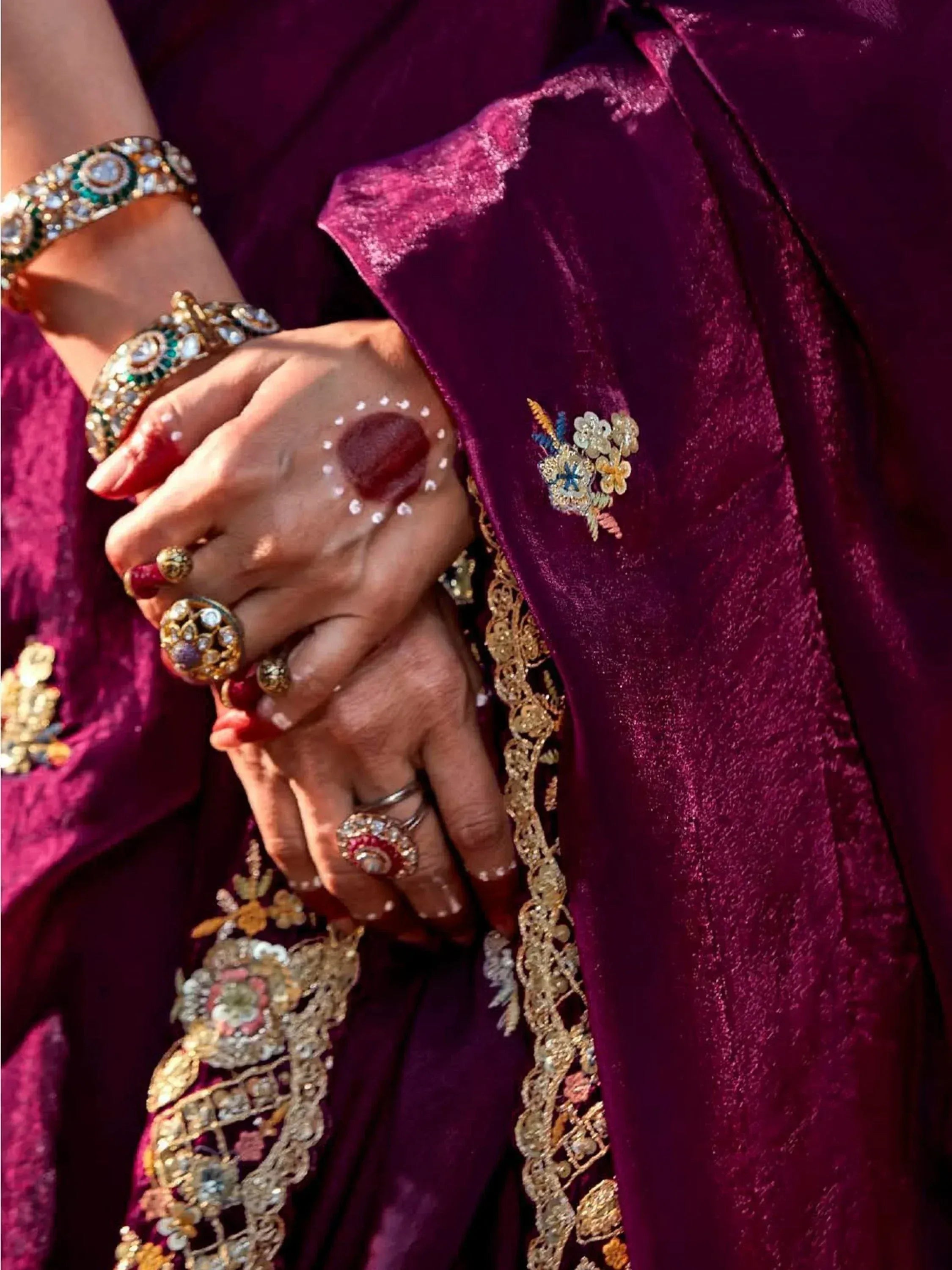 Rich purple velvet ethnic gown with gold embroidery, floral motifs, and traditional Indian jewelry for festive occasions.