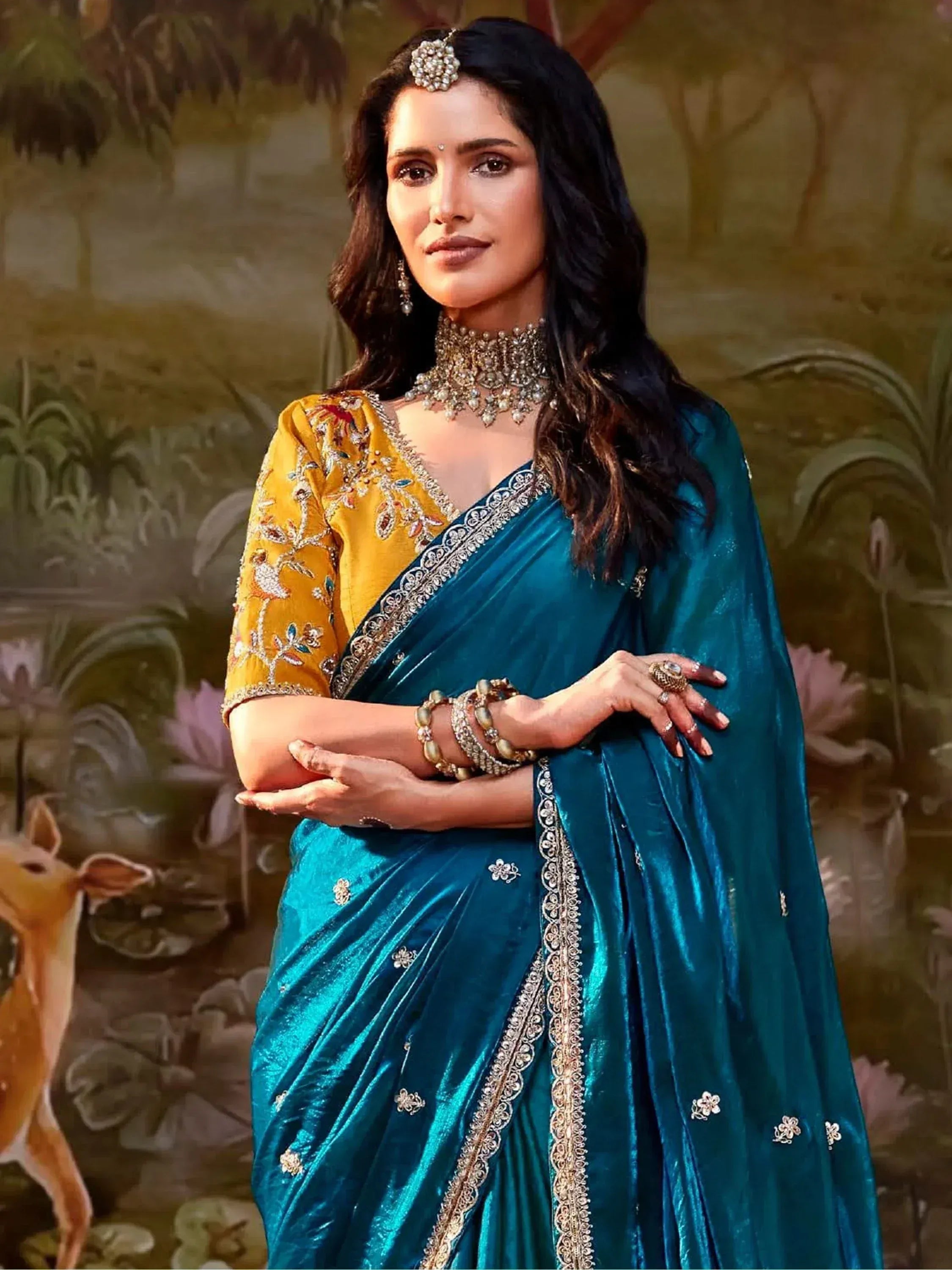 Teal velvet saree with gold embroidery, paired with yellow blouse and traditional jewelry for Indian ethnic wear