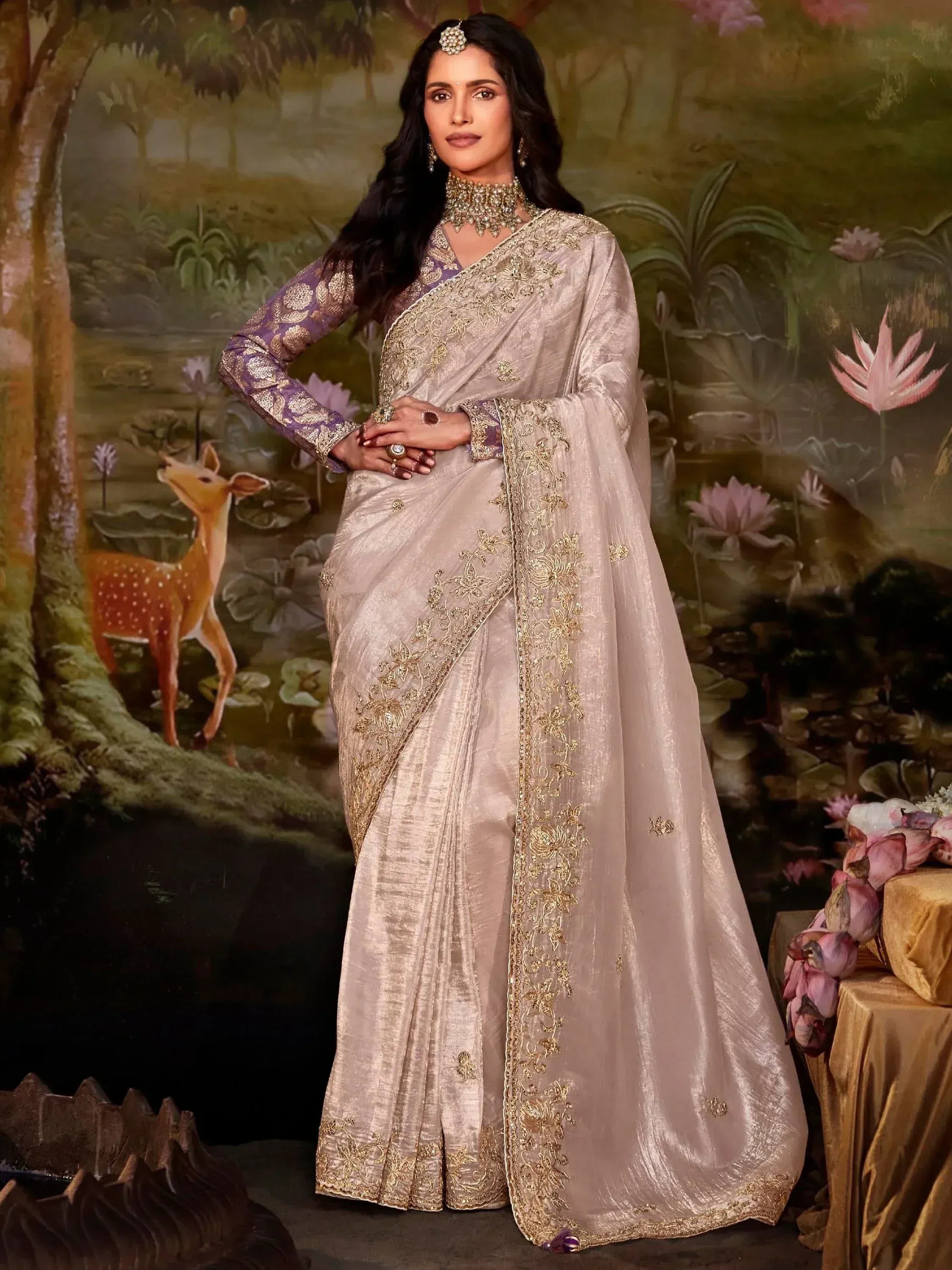 Elegant beige saree with gold embroidery, paired with purple blouse, perfect for Indian ethnic occasions.