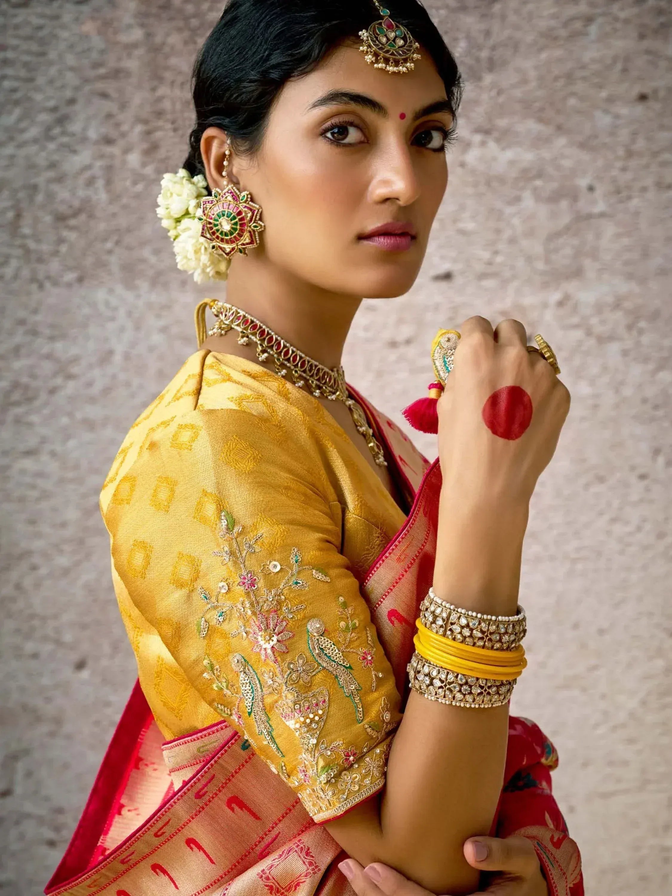 Woman in traditional Indian saree with gold embroidery, floral jewelry, and bindi, styled for festive occasions