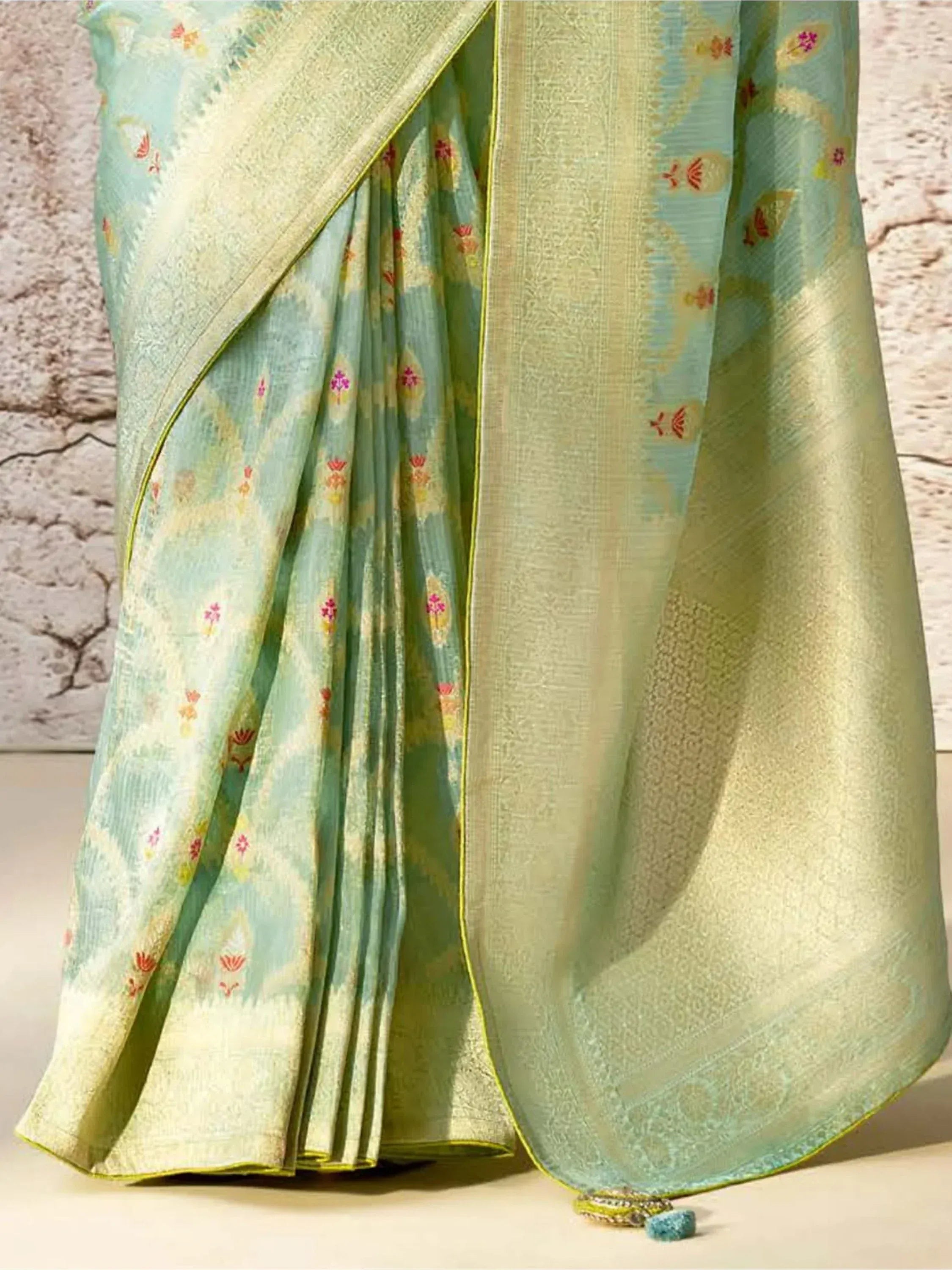 Light green designer saree with floral motifs and golden border, perfect for ethnic occasions