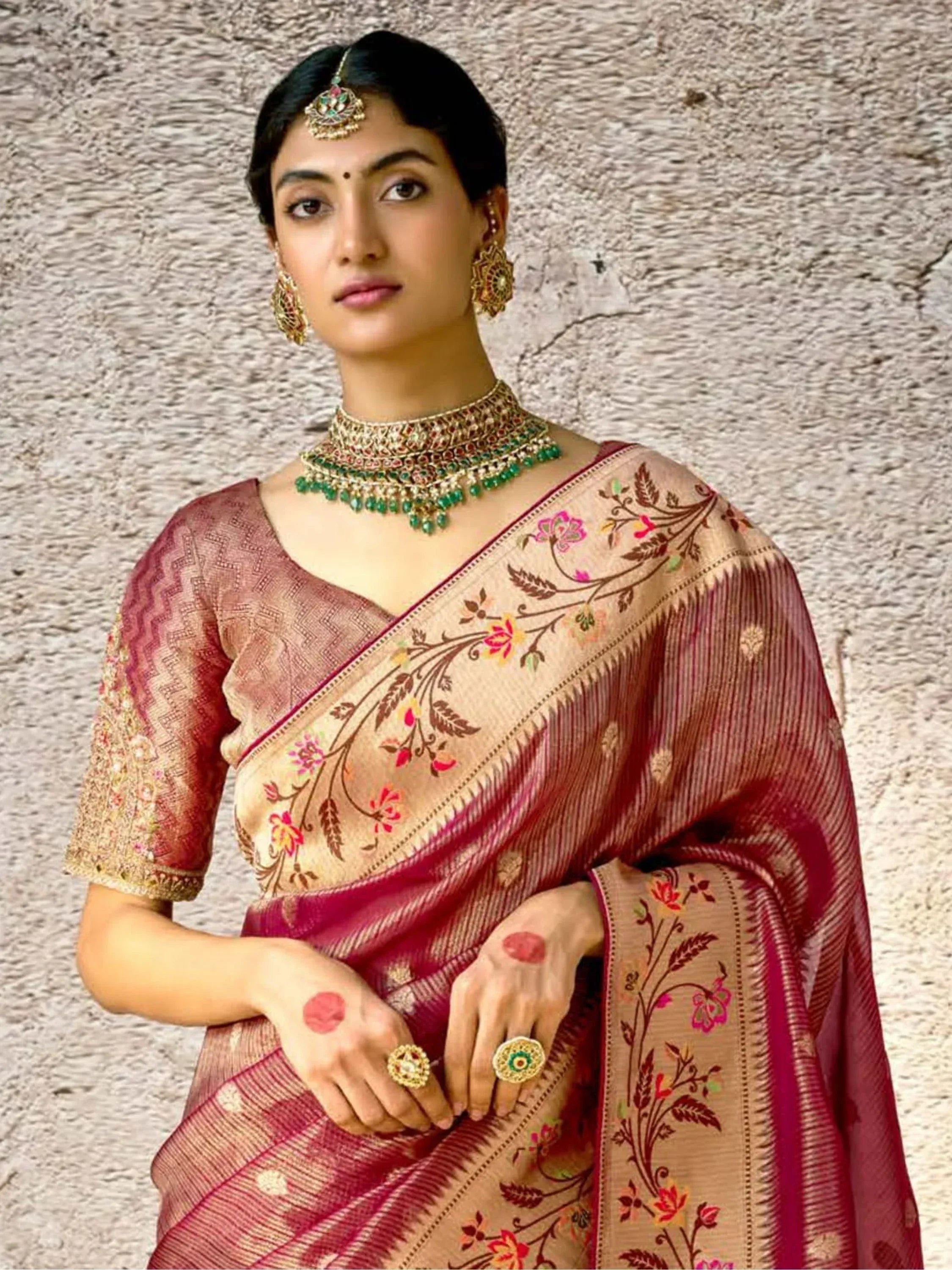 Woman in maroon and beige floral saree with gold embroidery, traditional Indian ethnic wear