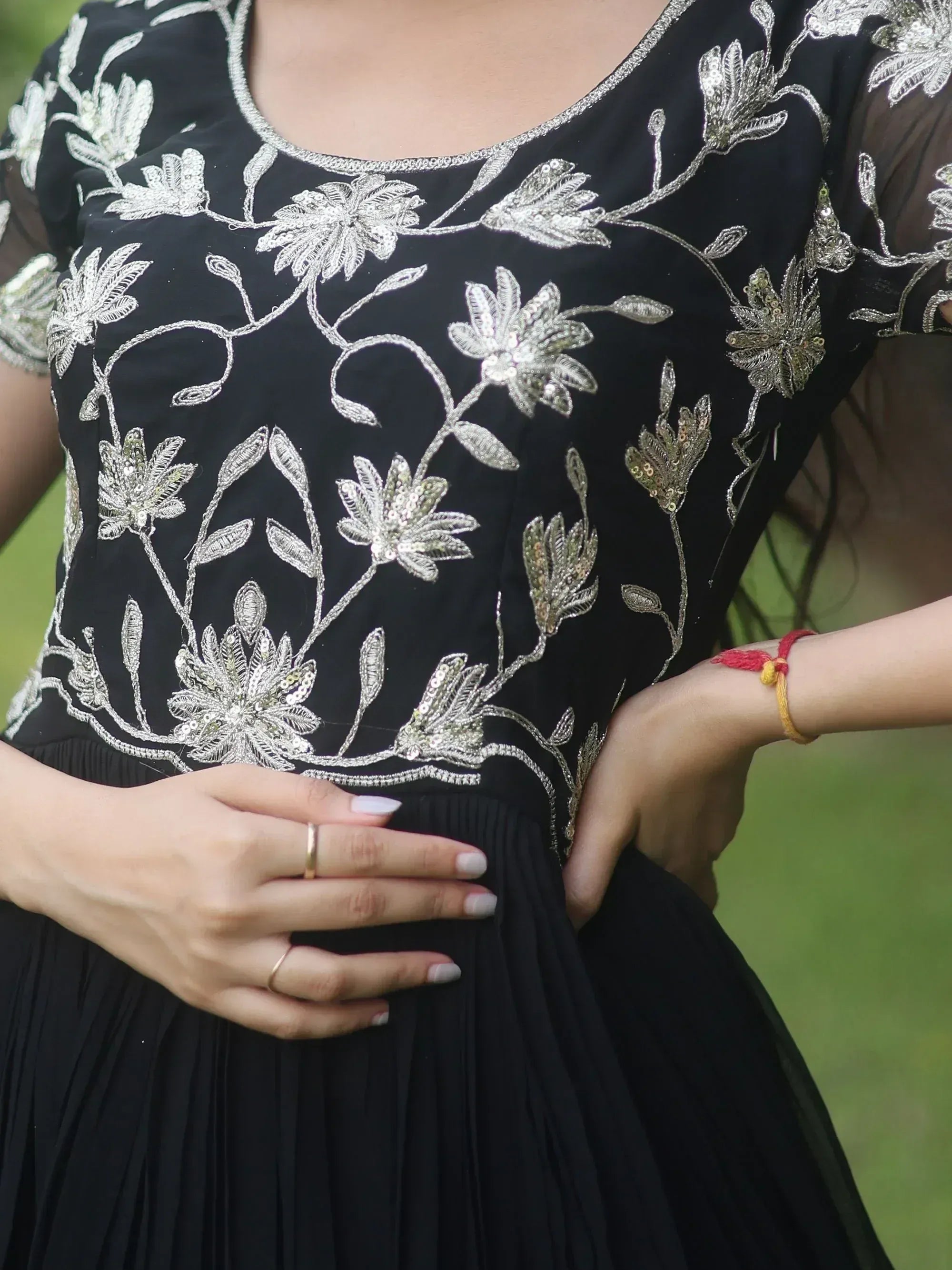 Black ethnic gown with silver floral embroidery and sheer sleeves, perfect for Indian occasions.