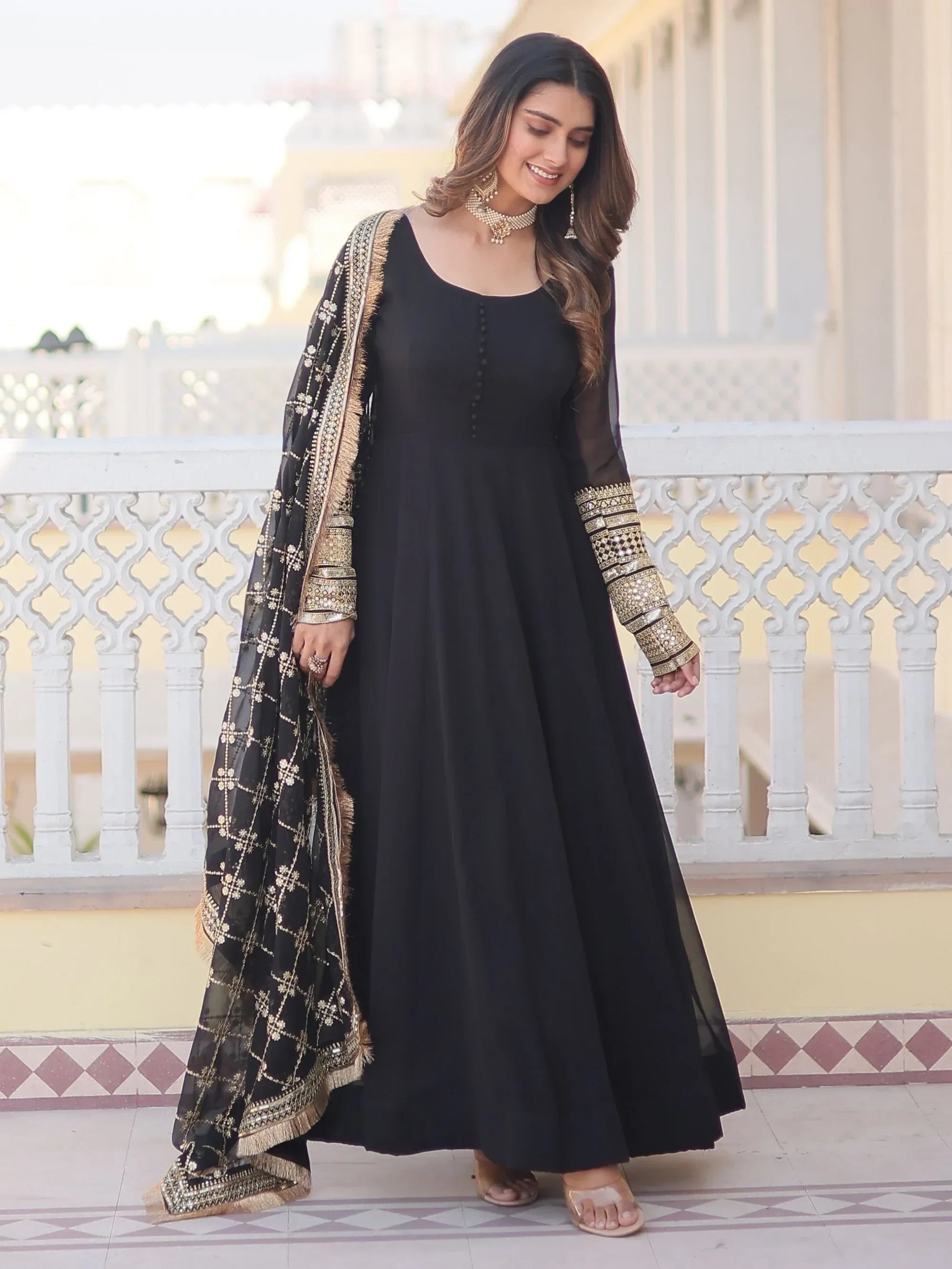 Woman wearing elegant black Anarkali suit with gold embroidered dupatta, ethnic dress