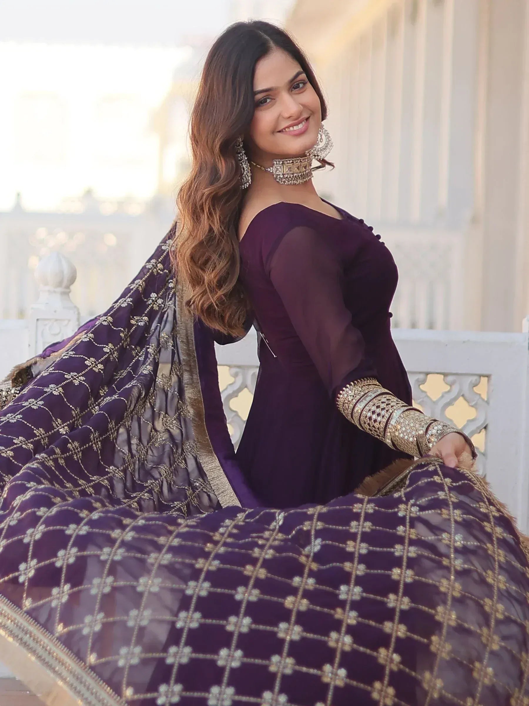 Woman in purple designer lehenga choli with gold embroidery, perfect for Indian ethnic wear occasions.