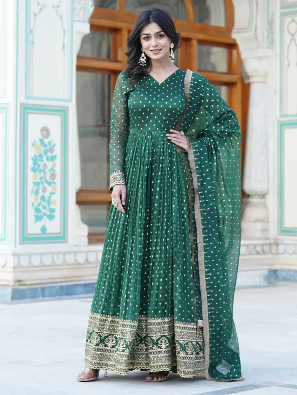 Emerald green ethnic anarkali gown with white polka dots and gold embroidery, perfect for Indian occasions.