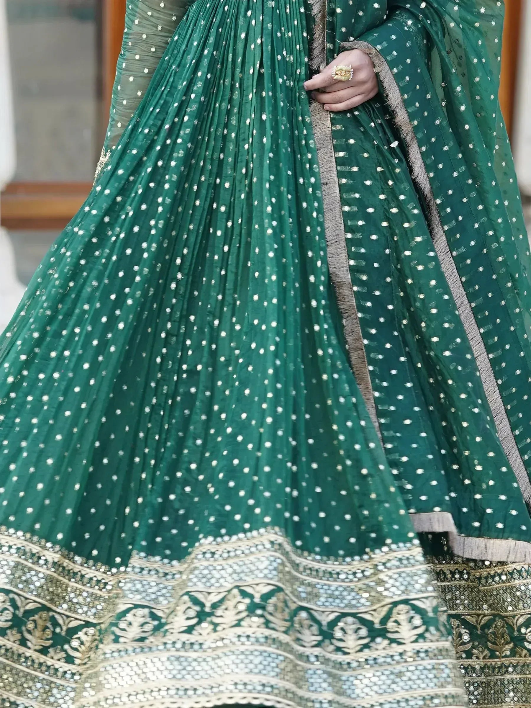 Emerald green designer lehenga choli with white polka dots and gold embroidery, perfect for Indian ethnic wear.