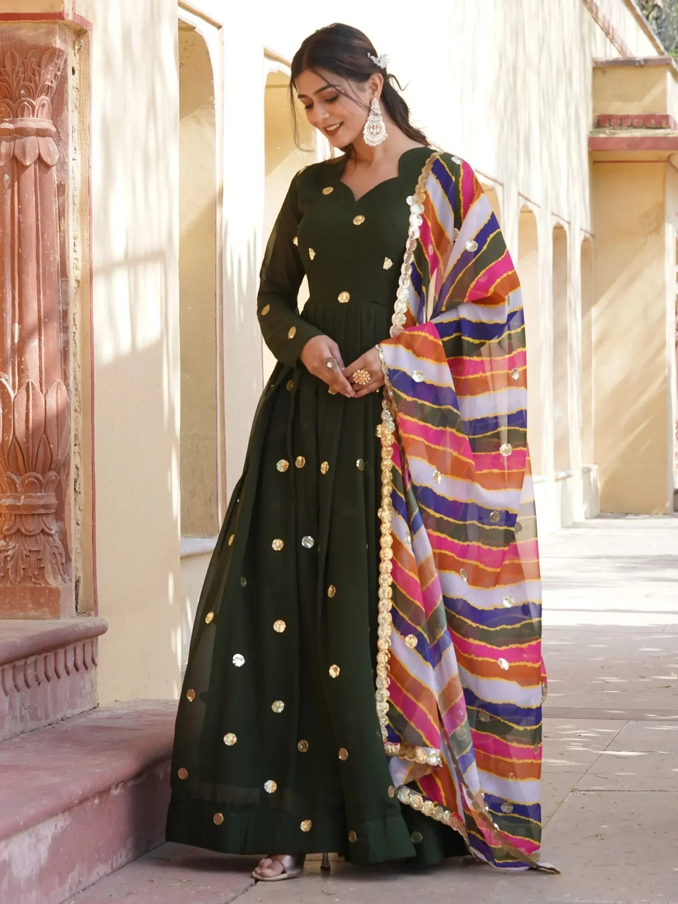 Green ethnic anarkali with gold embellishments and colorful striped dupatta, perfect for Indian occasions.