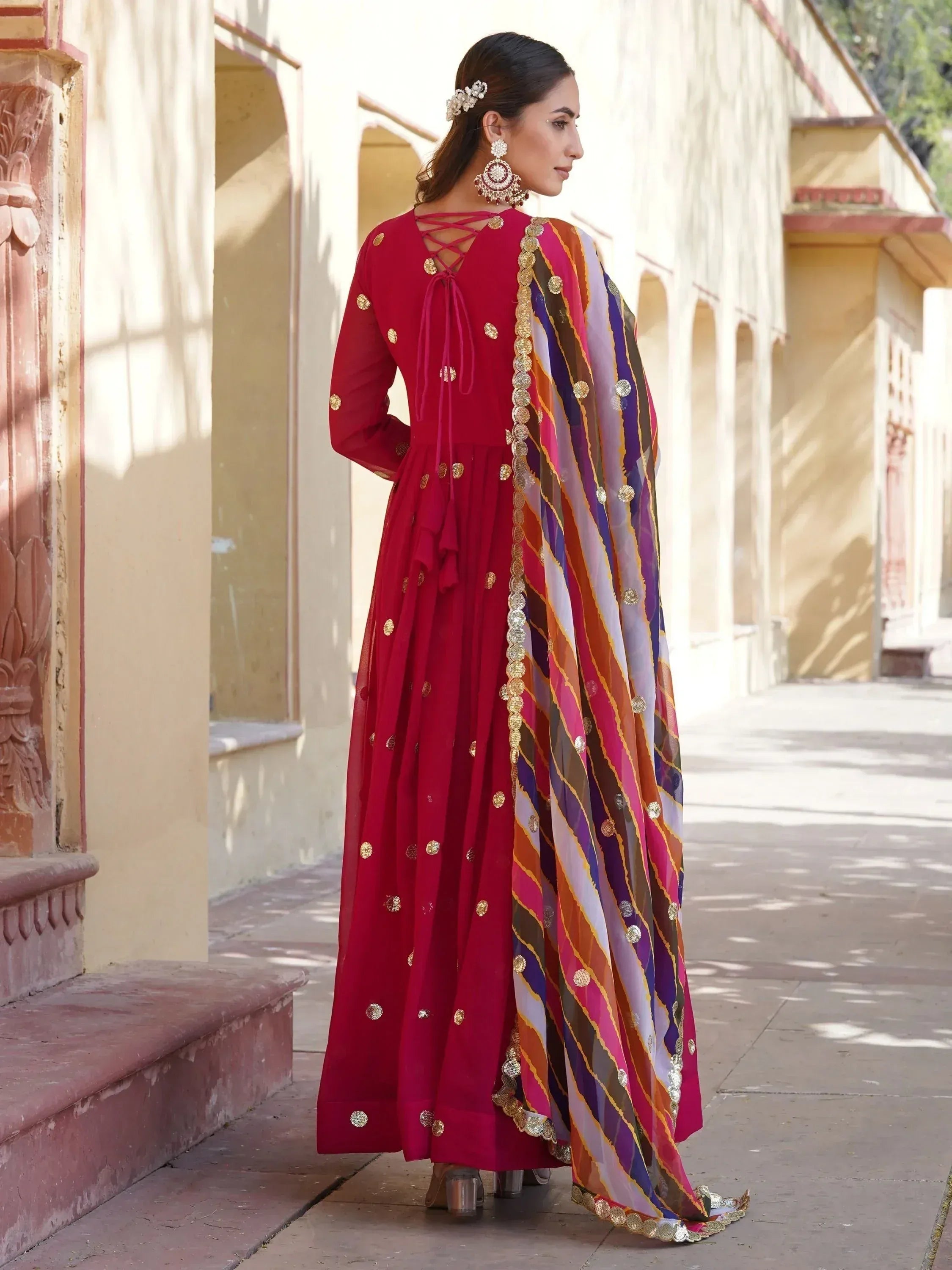 Red ethnic anarkali with gold embellishments and colorful striped dupatta, perfect for Indian occasions