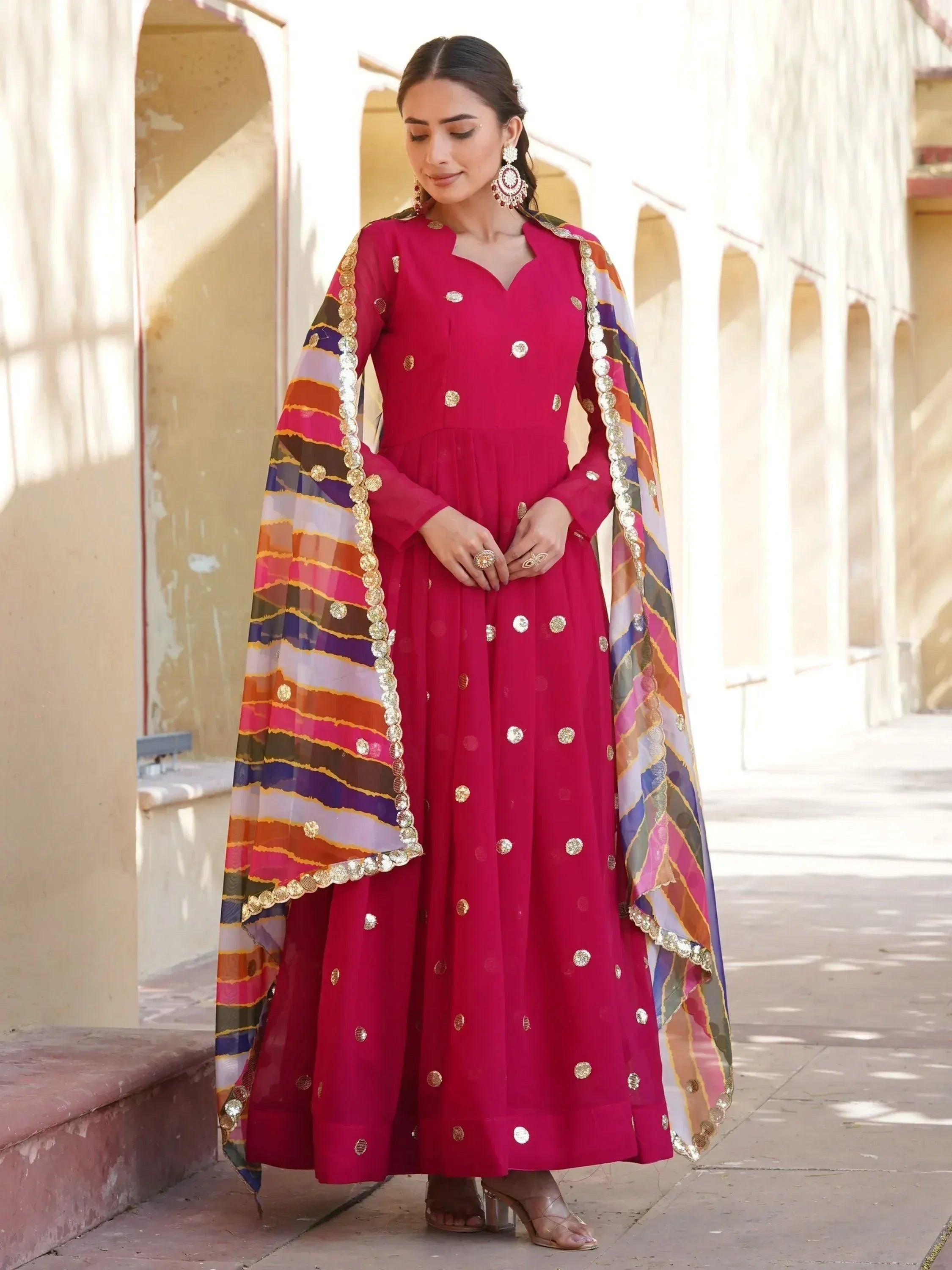 Elegant magenta anarkali with gold embroidery and colorful striped dupatta, perfect for Indian ethnic occasions