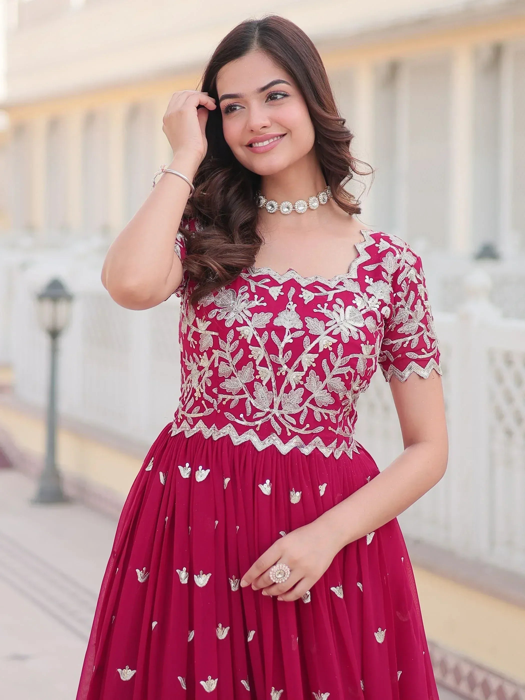 Woman in maroon ethnic gown with silver floral embroidery, perfect for Indian weddings and festive occasions