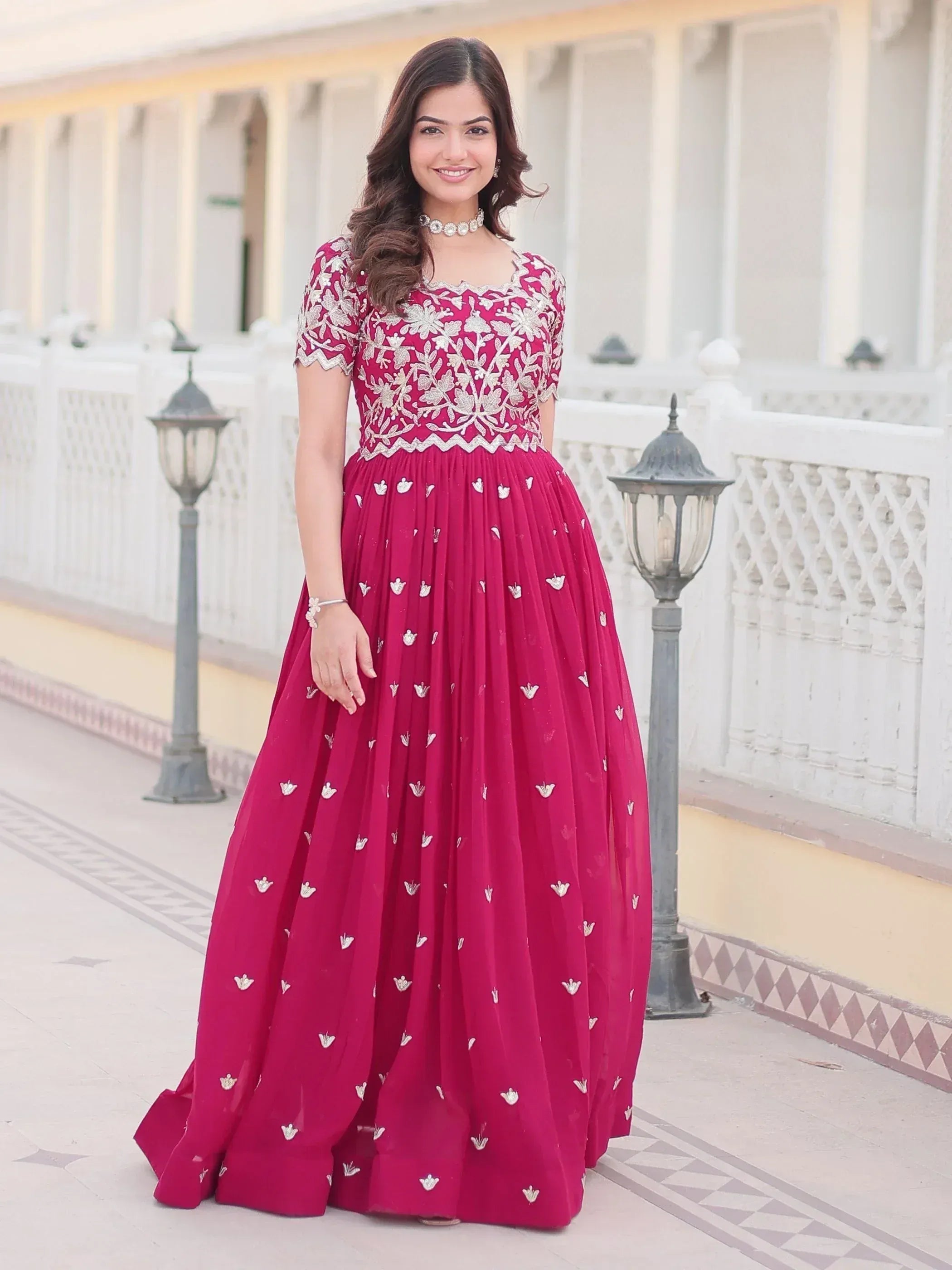 Elegant maroon ethnic gown with silver embroidery, perfect for Indian weddings and festive occasions.