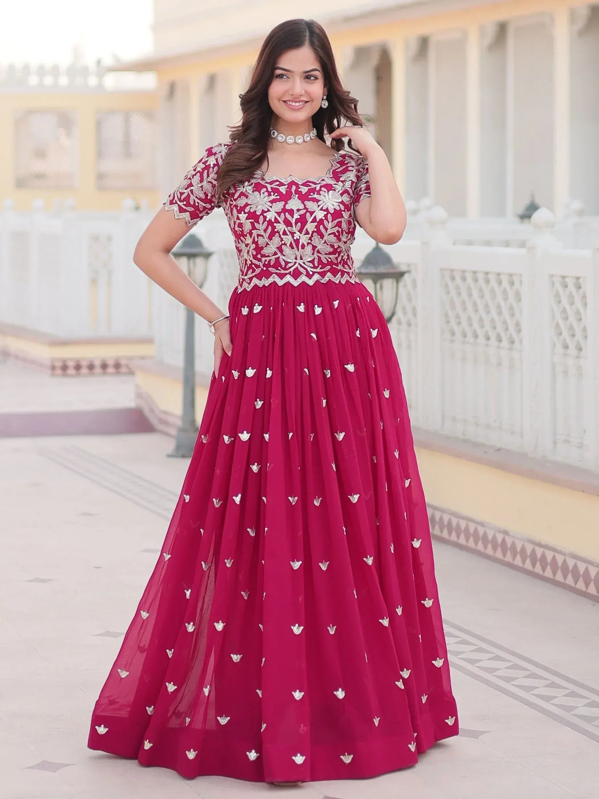 Elegant maroon ethnic gown with silver floral embroidery, perfect for Indian celebrations and weddings.