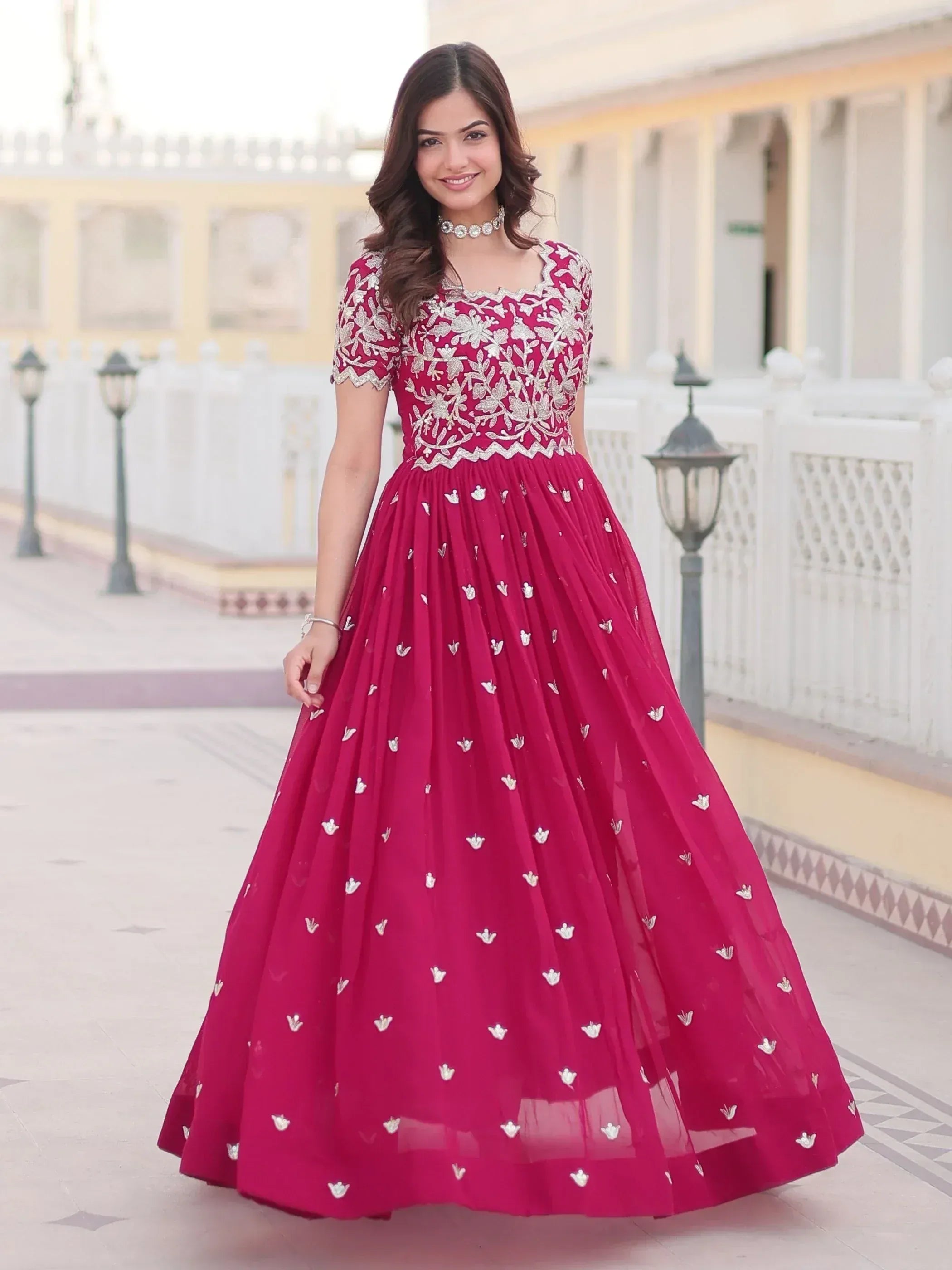 Elegant maroon ethnic gown with silver floral embroidery, perfect for Indian weddings and festive occasions.