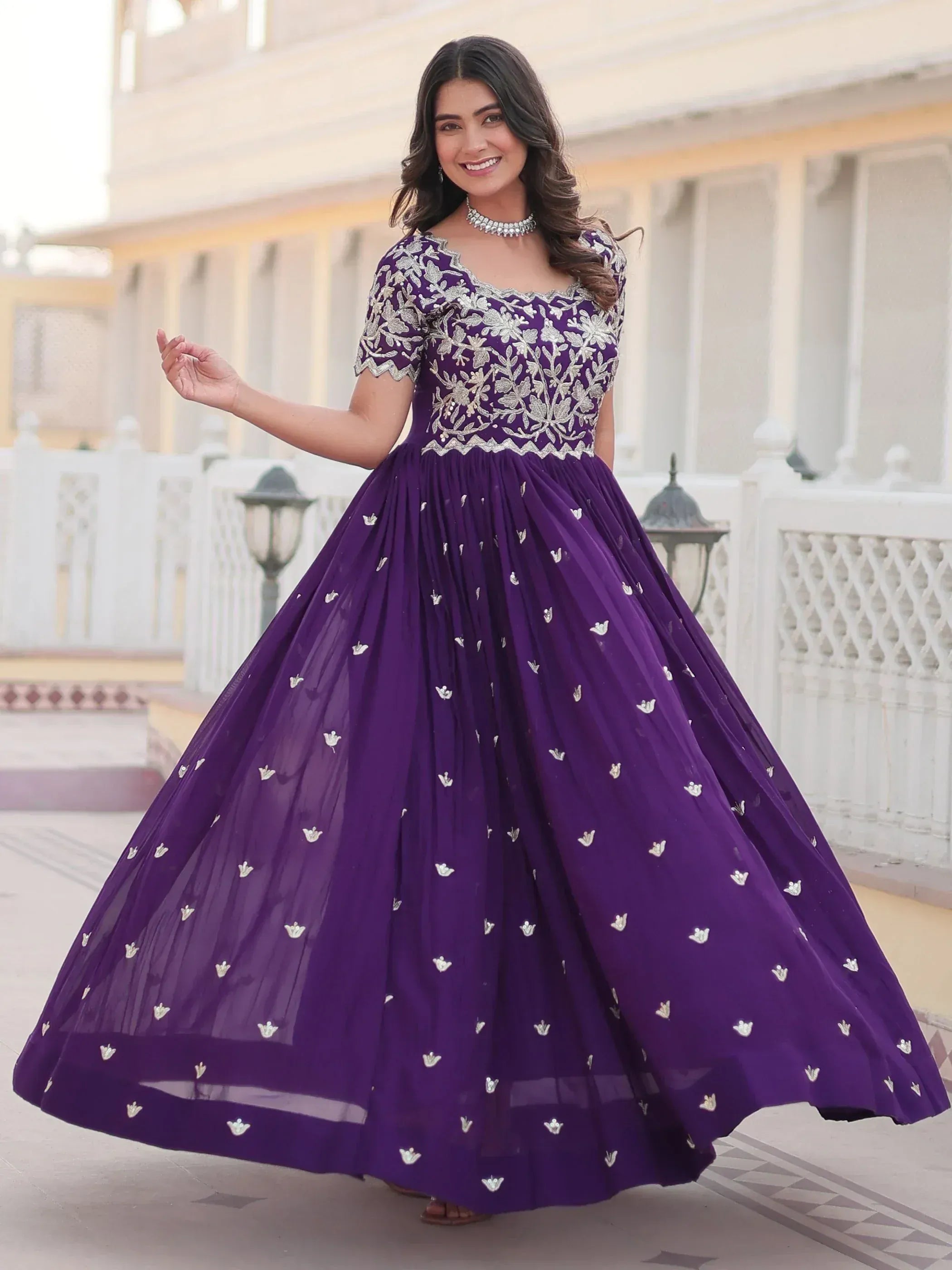 Purple embroidered ethnic gown with floral detailing, perfect for Indian weddings and festive occasions.