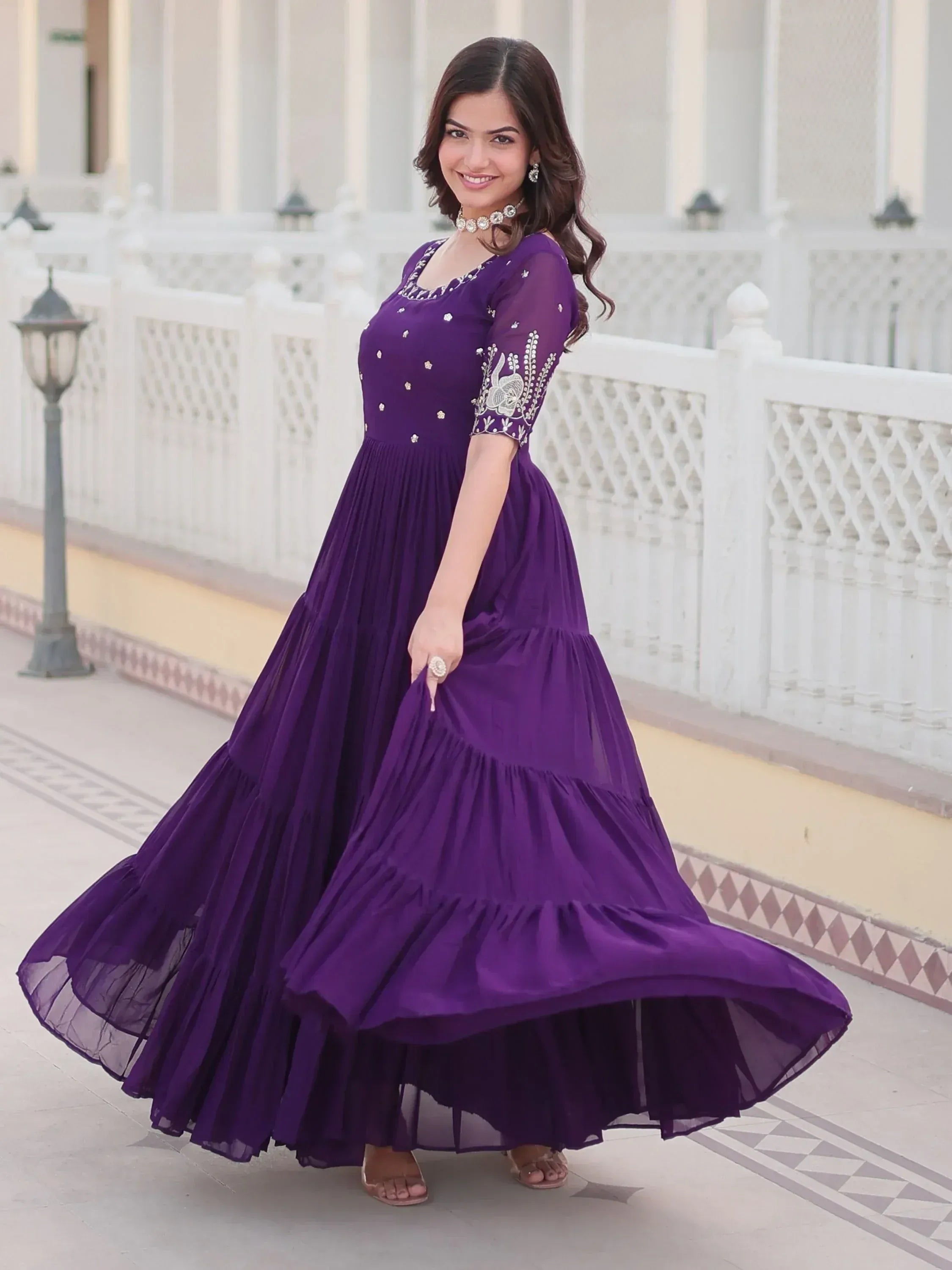 Purple ethnic gown with floral embroidery and tiered skirt, perfect for Indian occasions