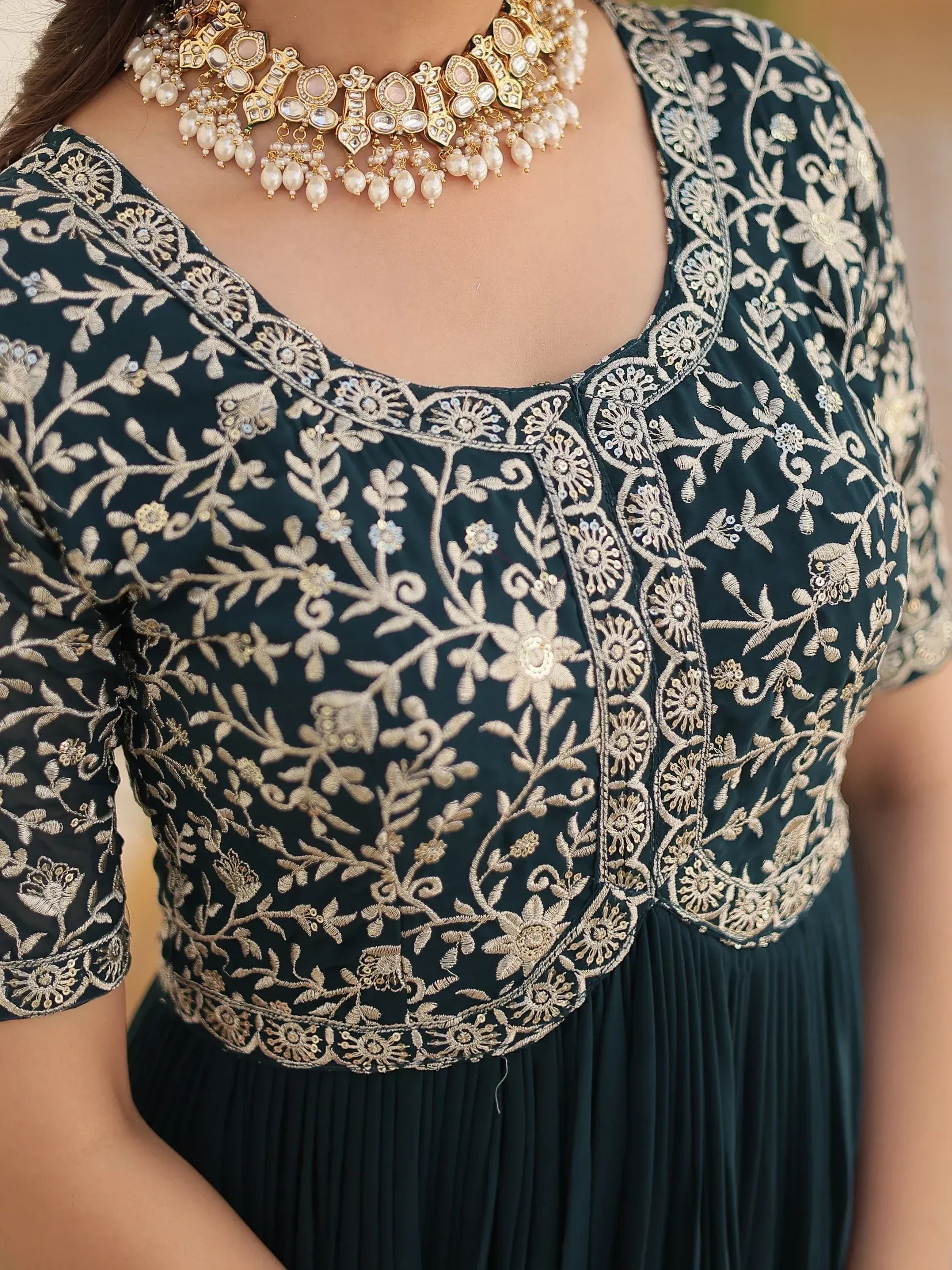 Dark green ethnic gown with gold floral embroidery and matching pearl necklace