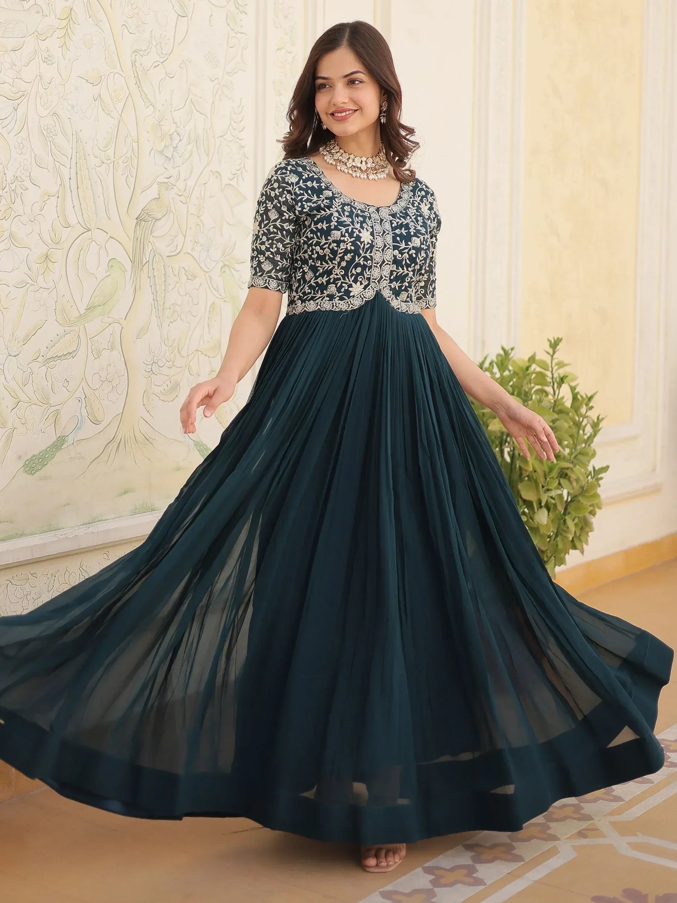 Woman in elegant dark green ethnic gown with floral embroidery and pleated skirt, perfect for Indian occasions