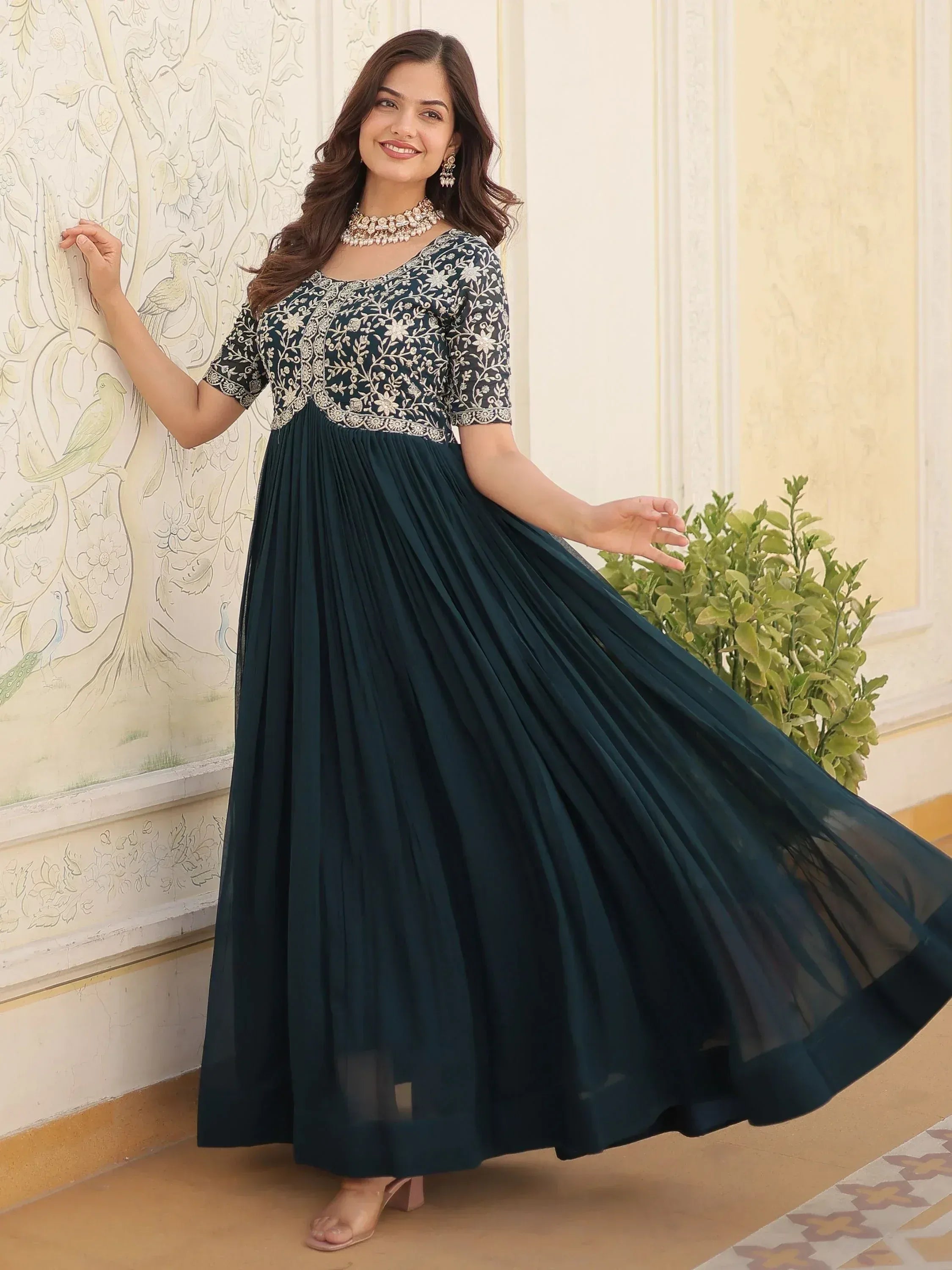 Elegant dark green ethnic gown with floral embroidery and pleated skirt, perfect for Indian occasions