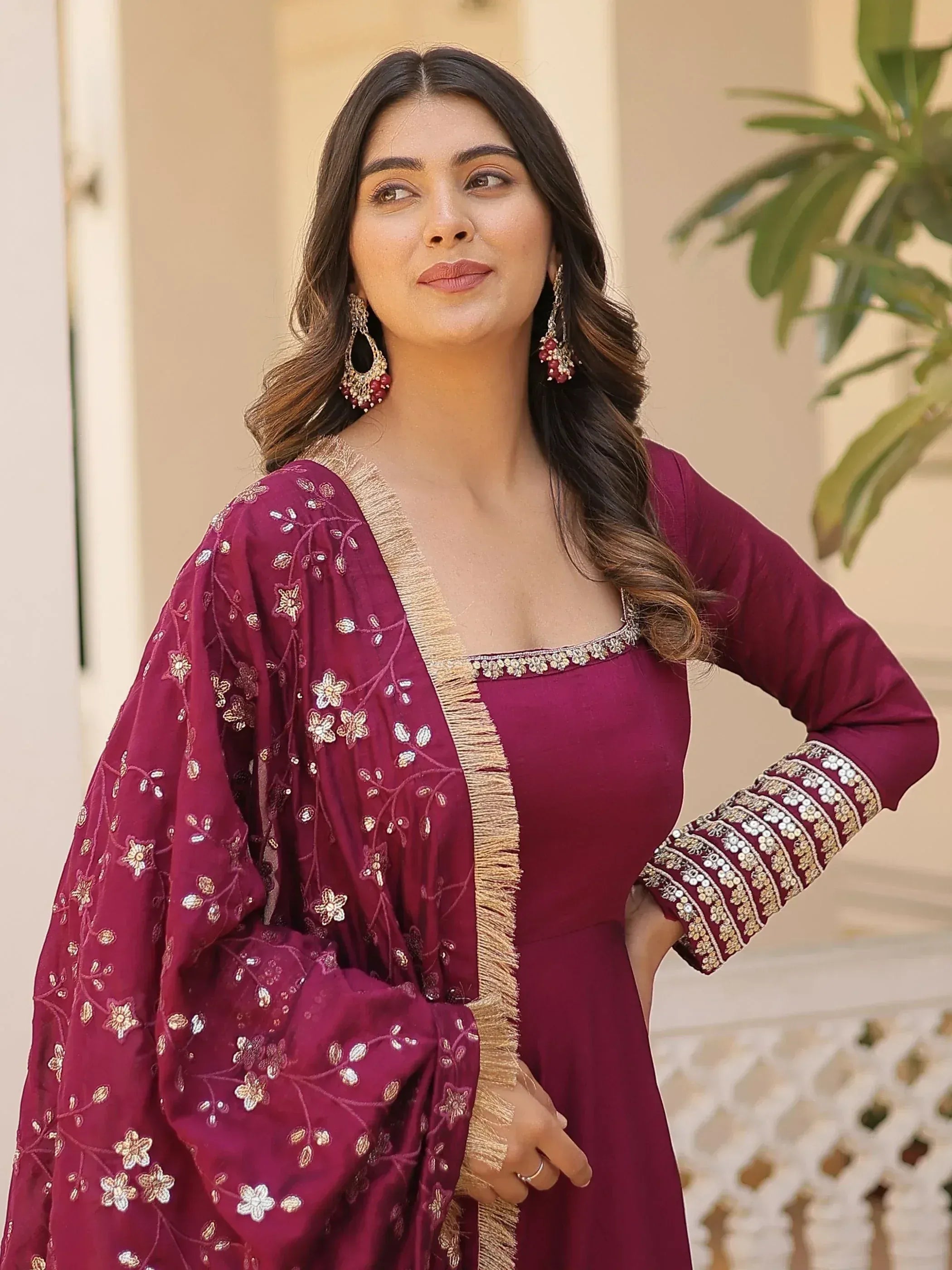 Maroon embroidered ethnic gown with floral detailing and gold trim, perfect for Indian occasions