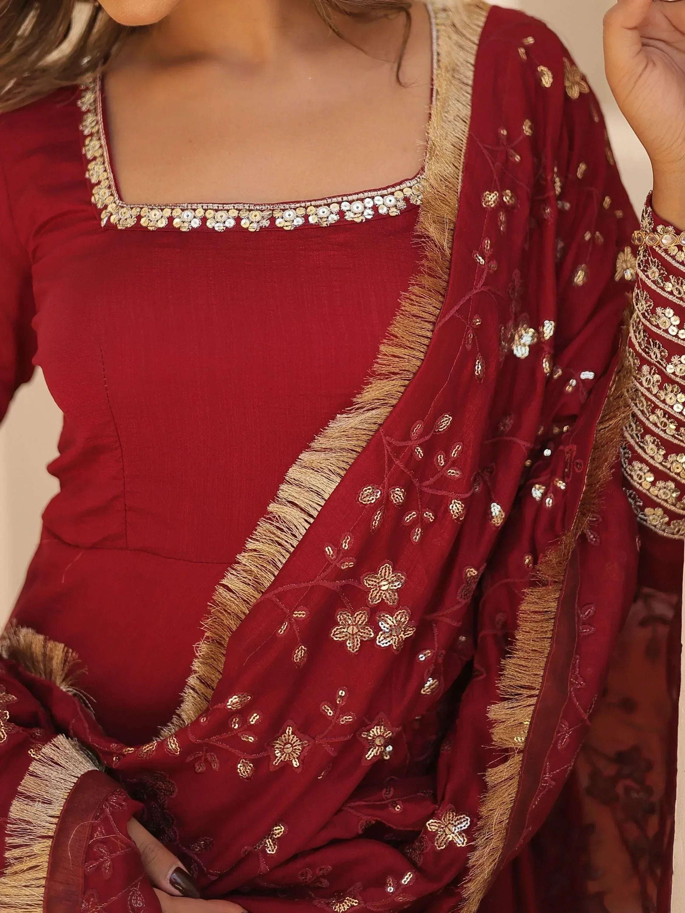 Maroon ethnic salwar kameez with gold embroidery and tassels, perfect for festive occasions