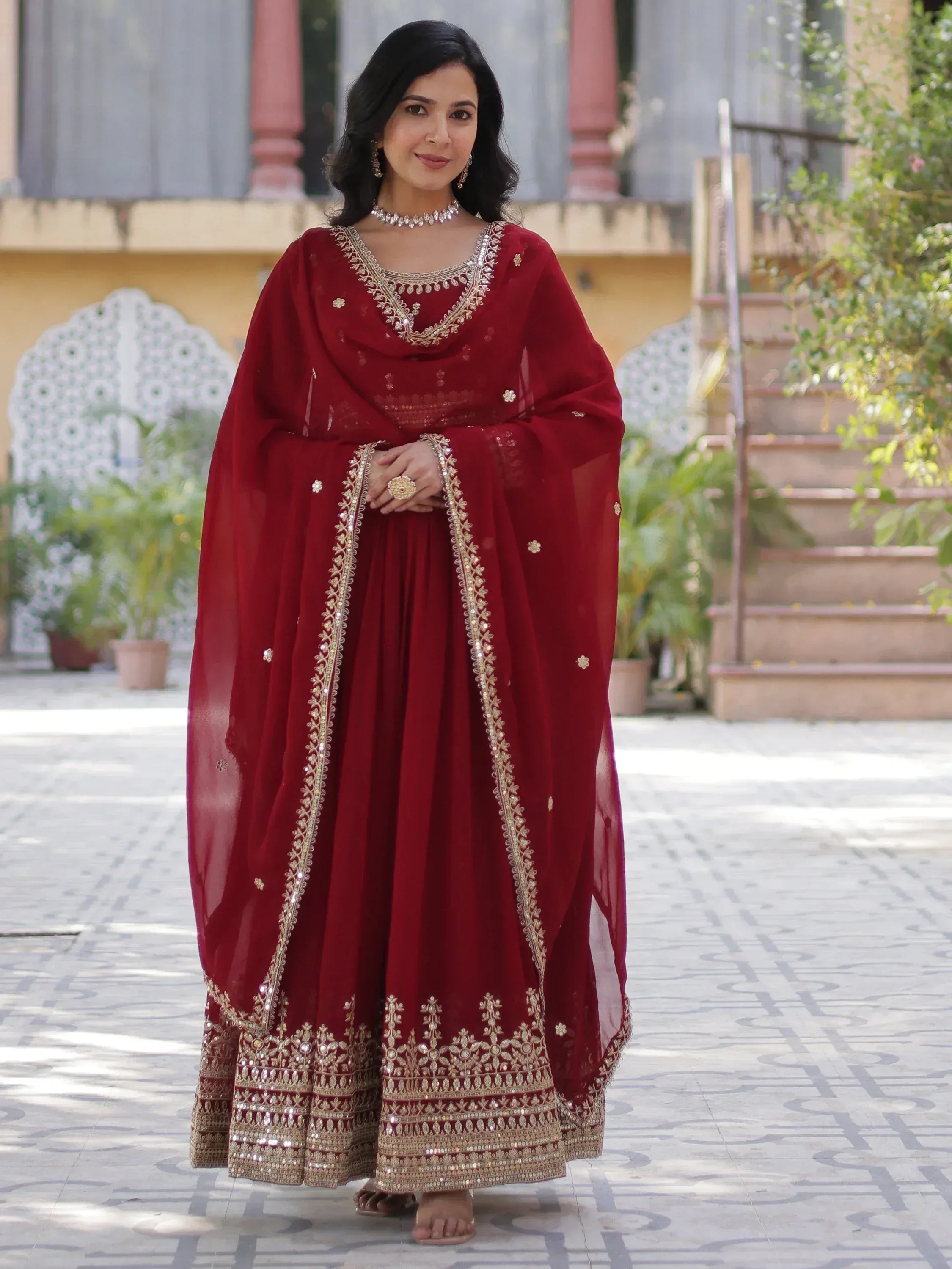Maroon Indian ethnic gown with gold embroidery, perfect for weddings and festive occasions.