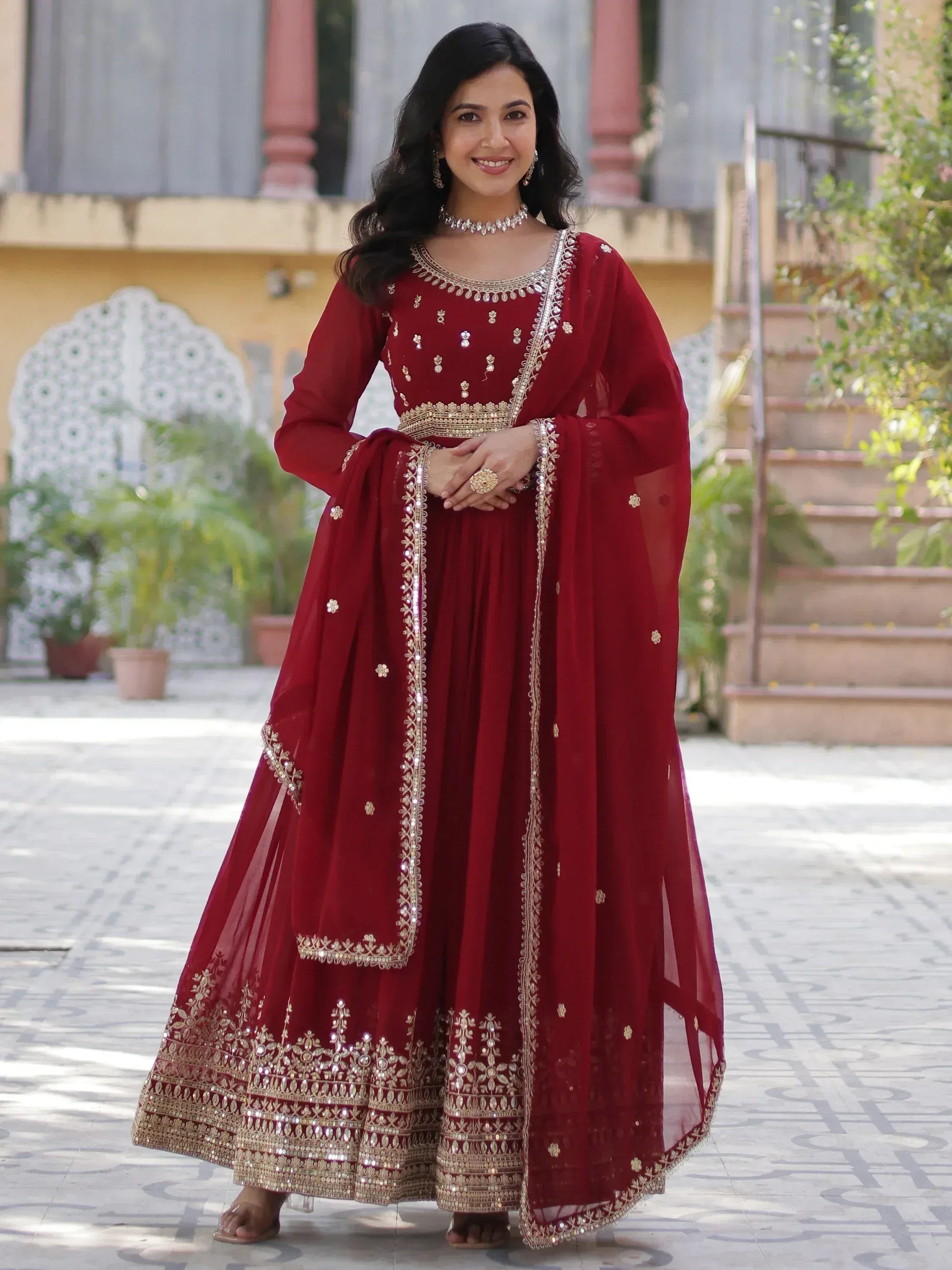 Elegant maroon ethnic gown with gold embroidery and embellishments, perfect for Indian celebrations.