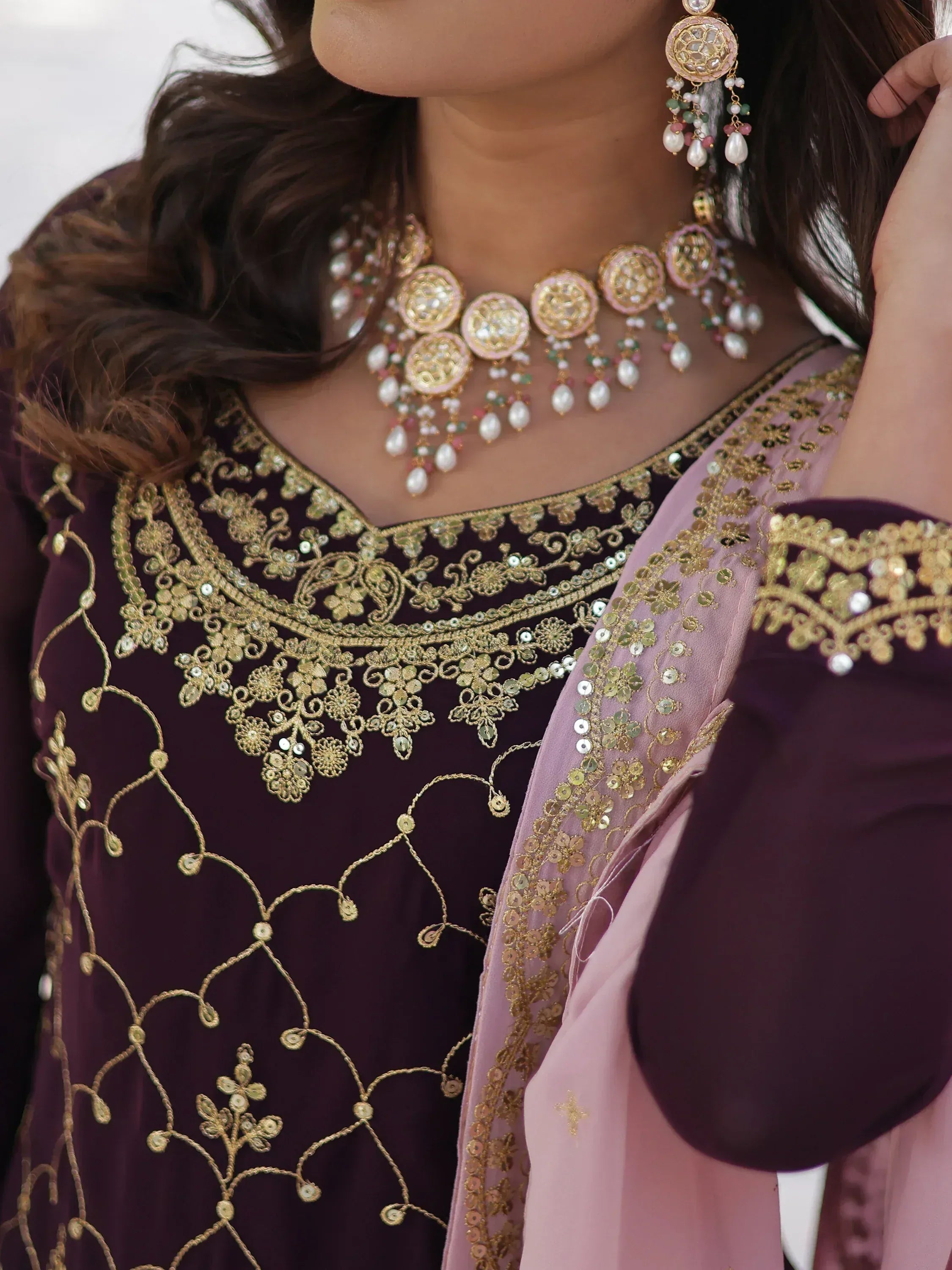 Elegant purple ethnic wear with gold embroidery, paired with matching jewelry for Indian festive occasions